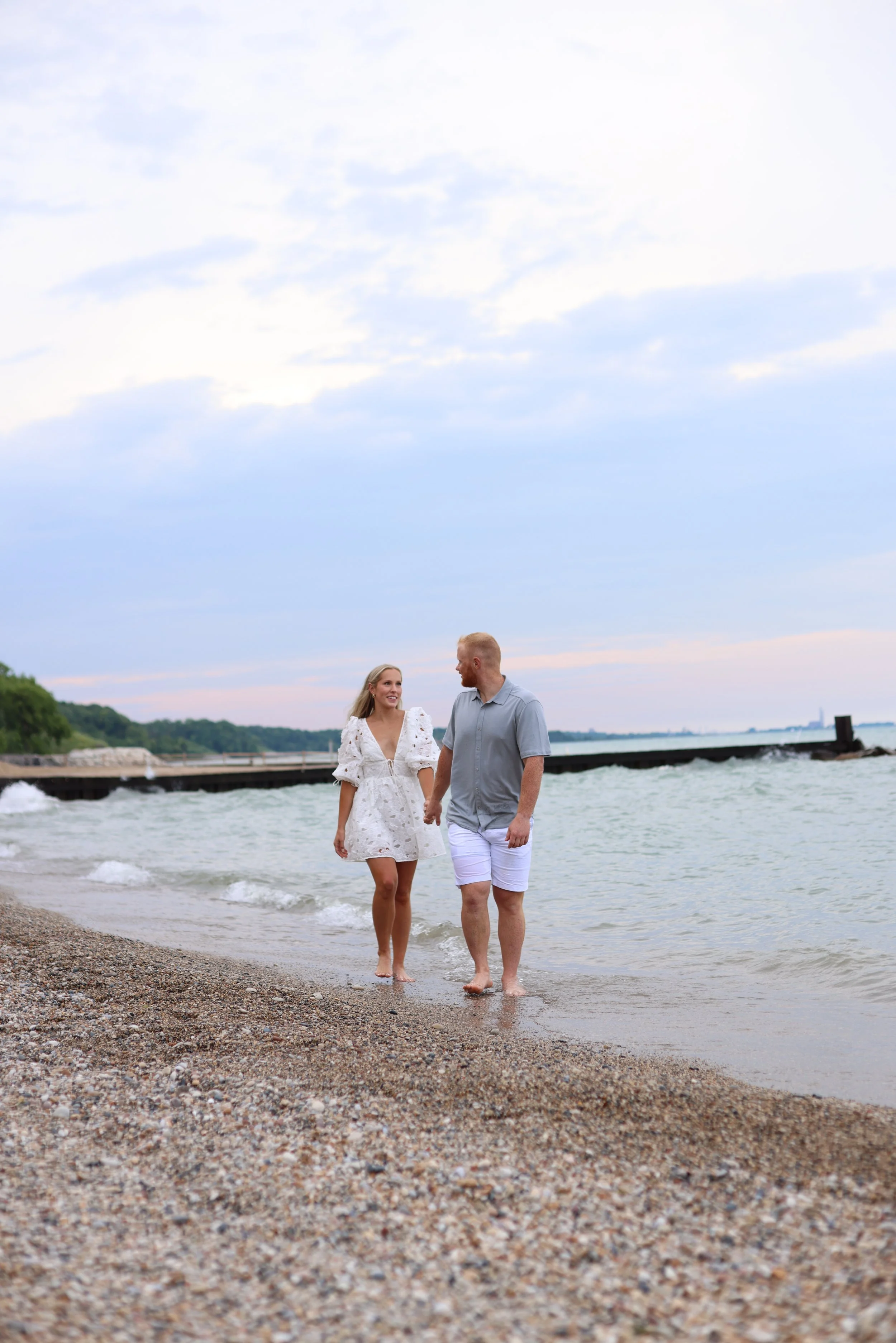 Couple walking on a pebble beach by the sea