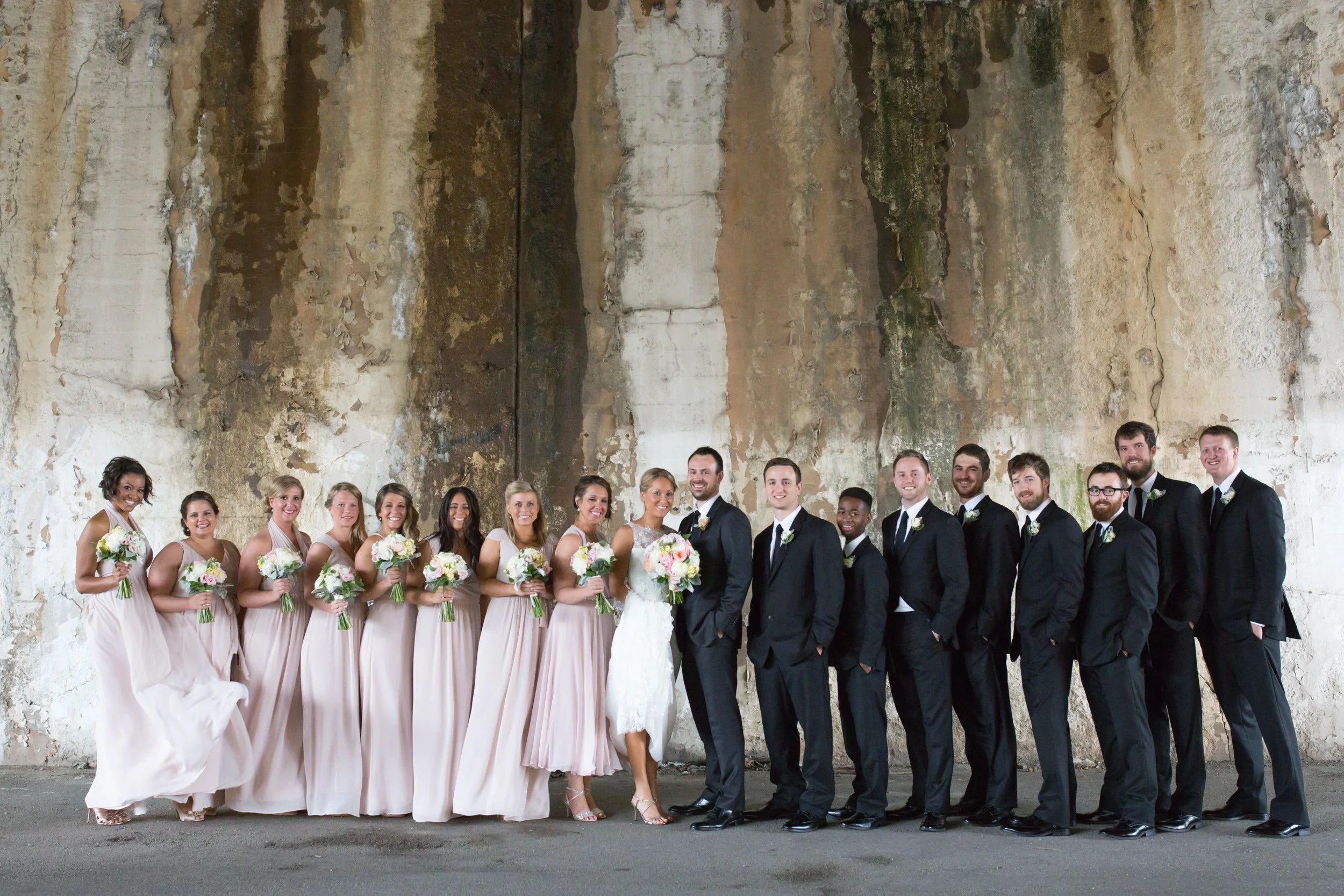 bride and groom with bridal party under a bridge portrait Chicago wedding photographer near me