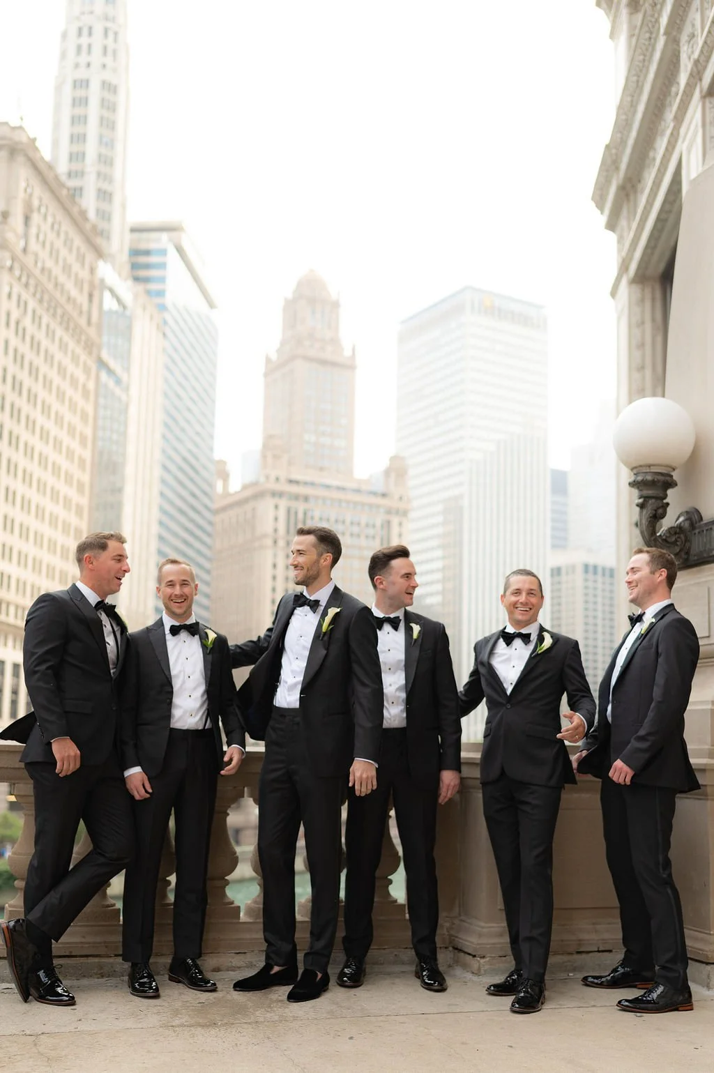 Groomsmen laughing for the wedding photographer near the Wrigley Building in Chicago