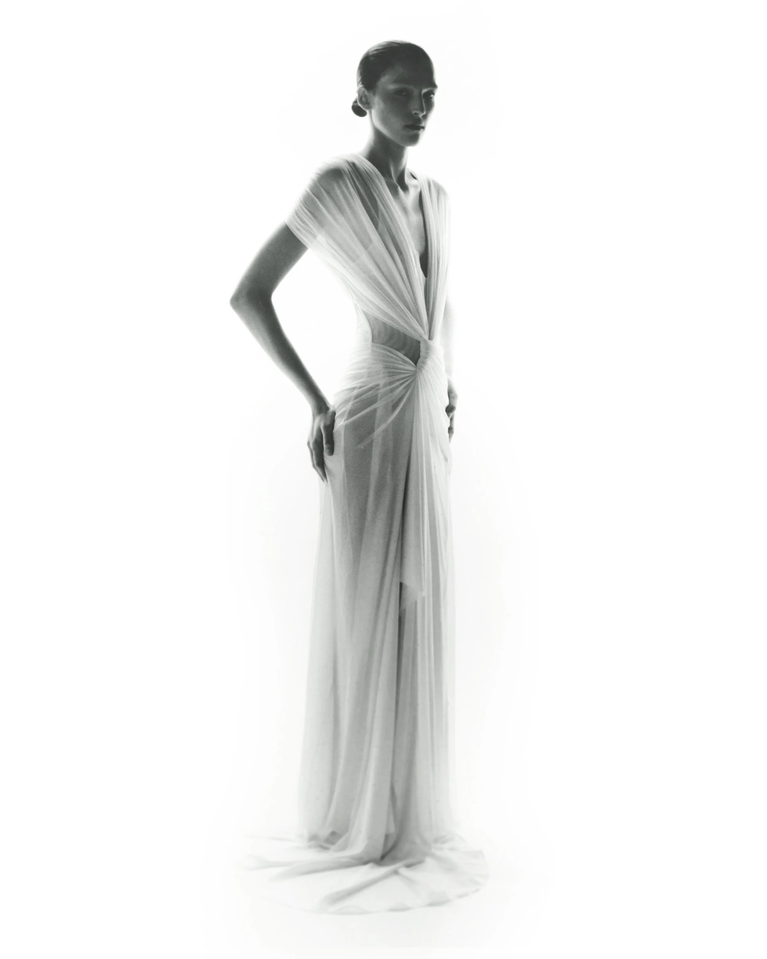 Black and white photo of a woman in a flowing, elegant gown.