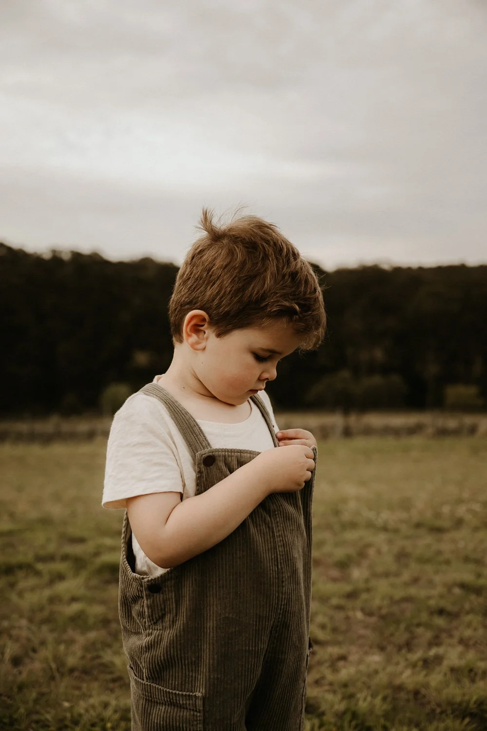 Young boy adjusting clothing during family photo session