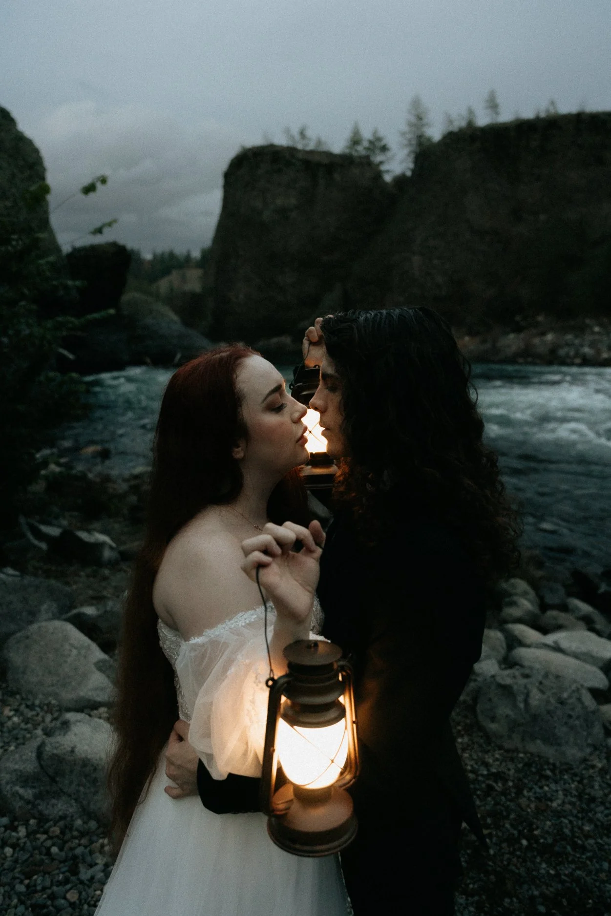 Couple leaning in for a kiss while holding lanterns on their wedding day