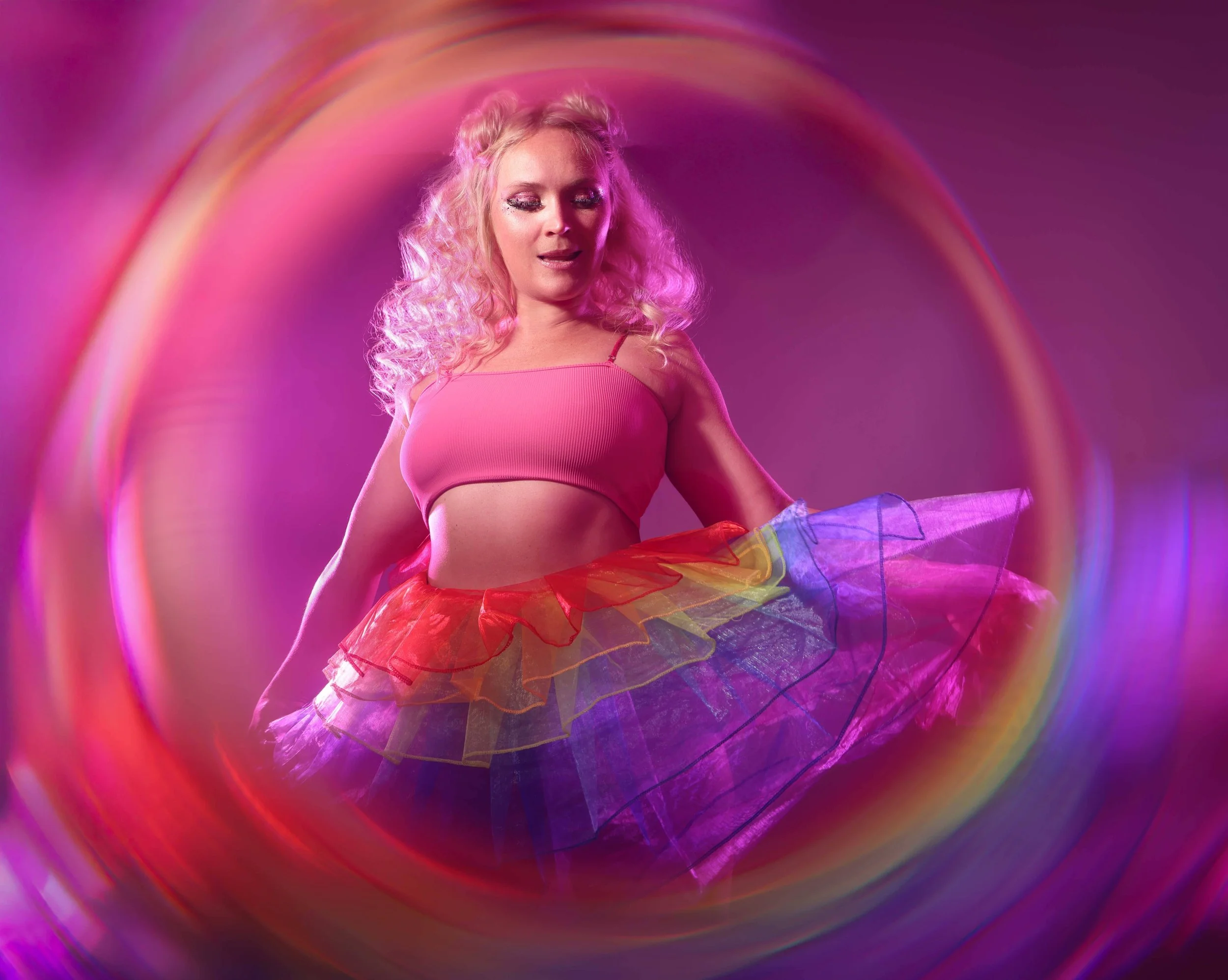 Creative and colorful studio session with a woman posing in a rainbow dress