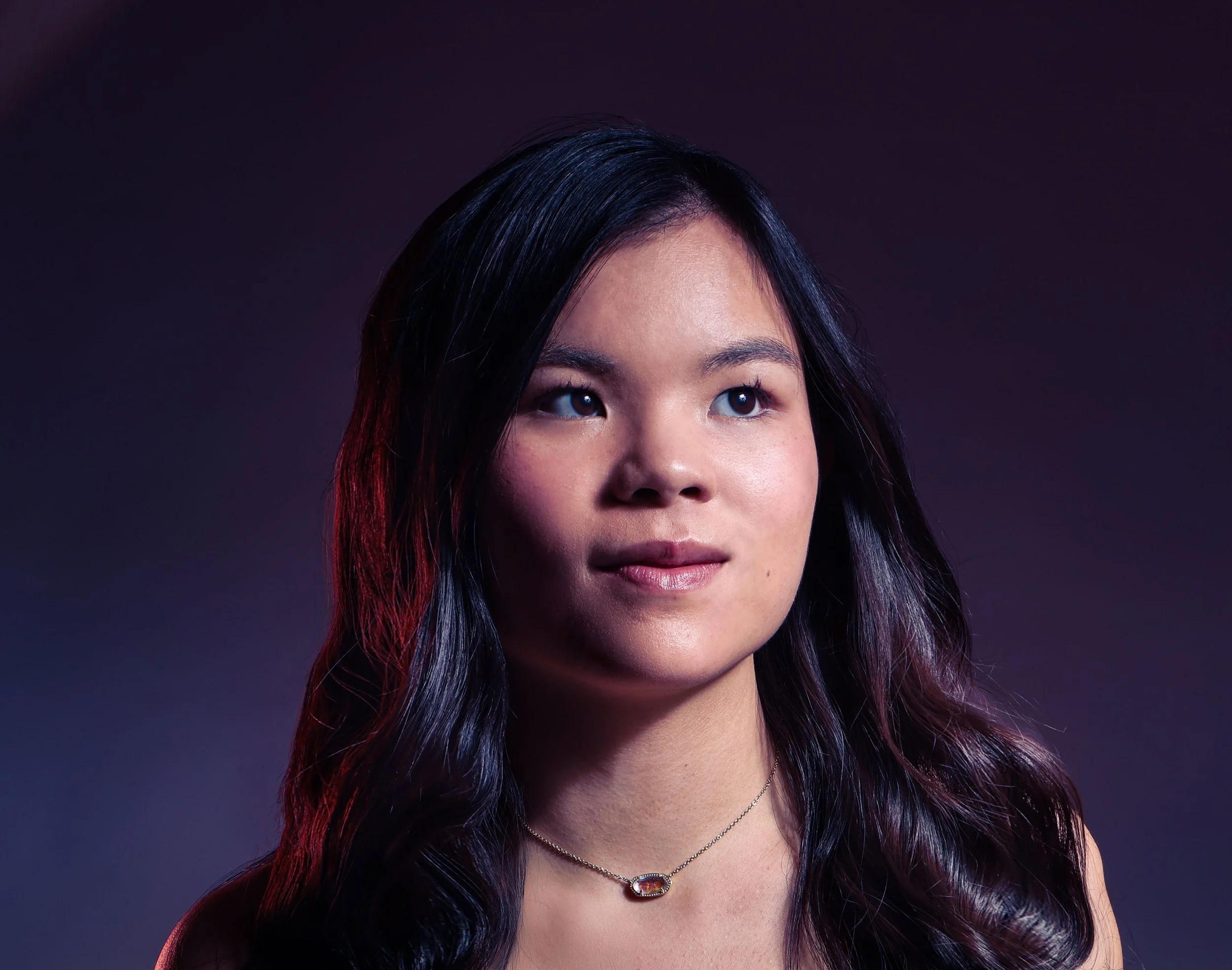 Head shot of a asian American girl with long black hair and red rim light 