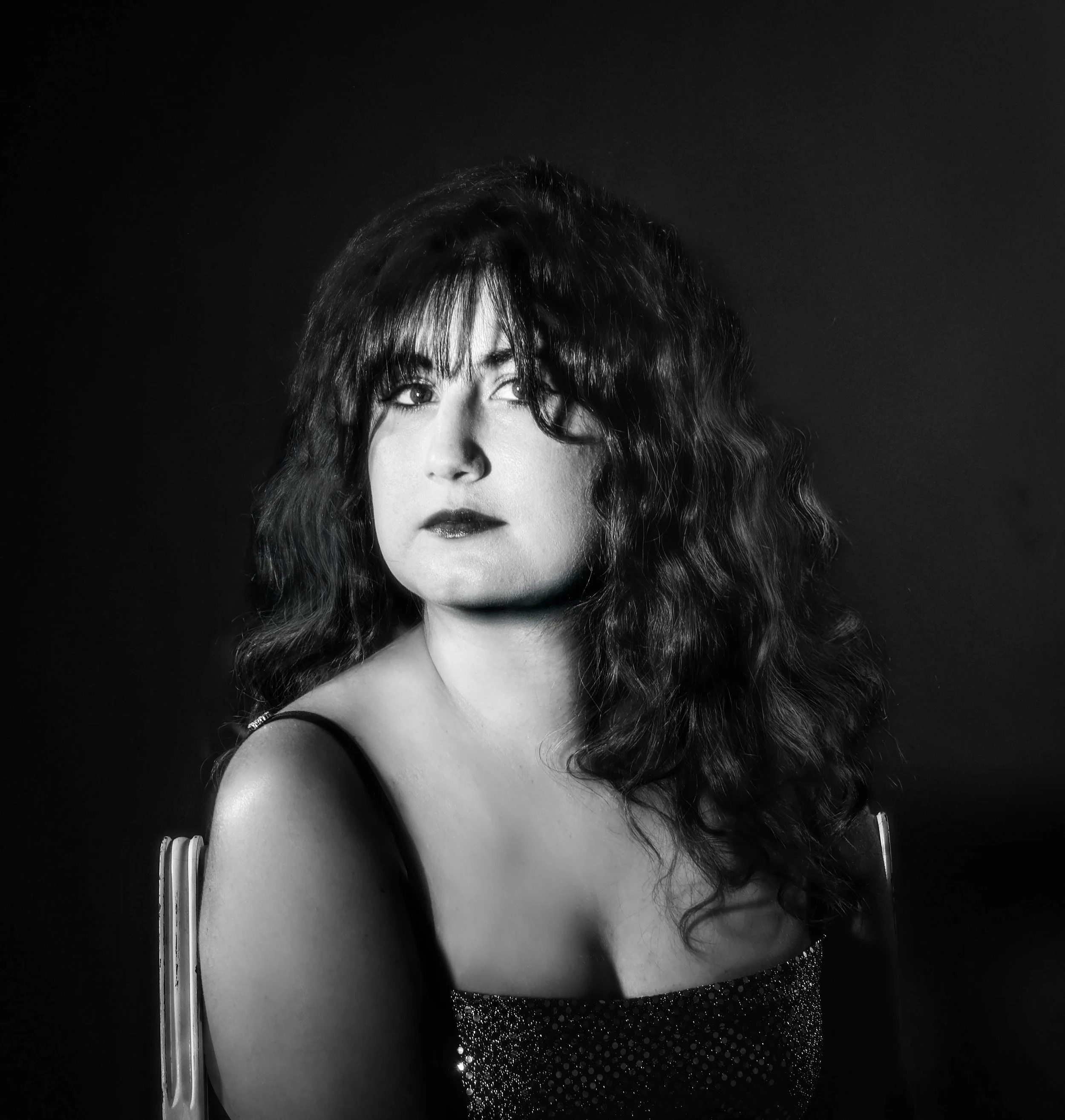 Dramatic black and white portrait of a woman with long curly hair 