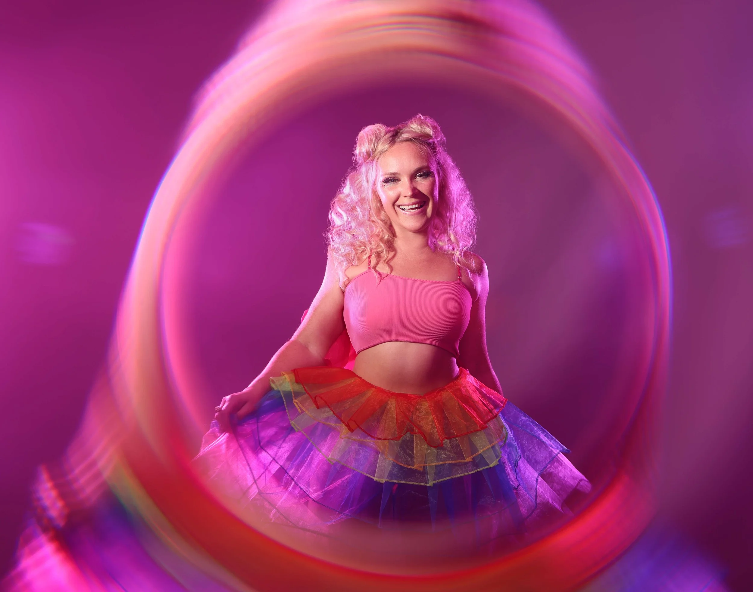Colorful portrait of a woman with blond hair wearing a rainbow skirt with a creative filter effect. 