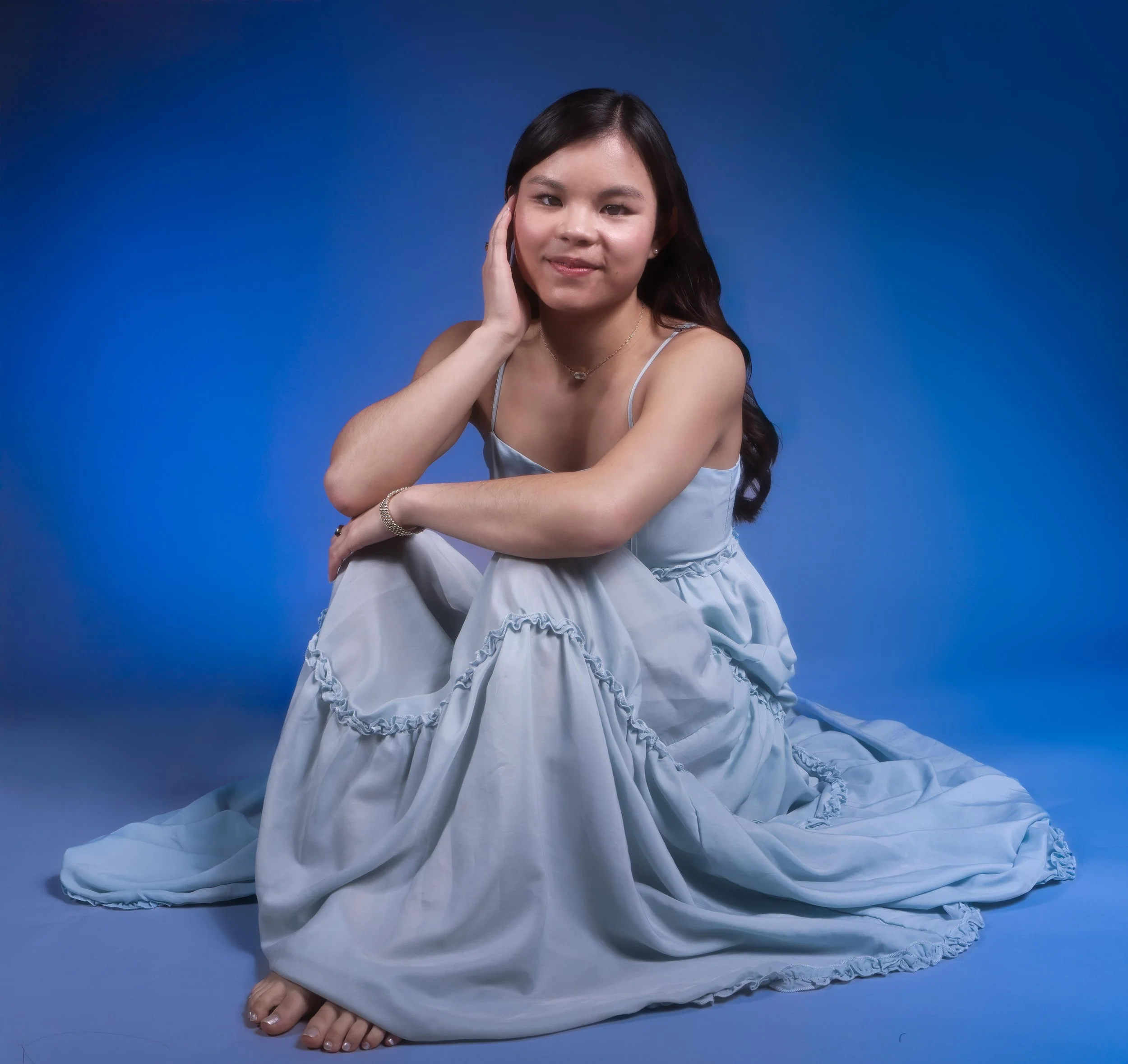 Studio portait of an Asian American student wearing a blue dress 