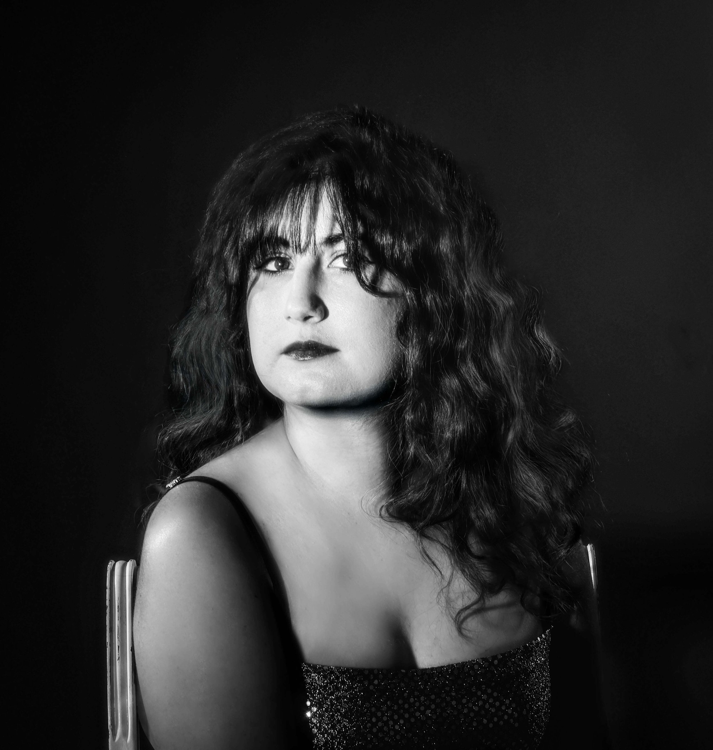 black and white image of a woman posing in a chair