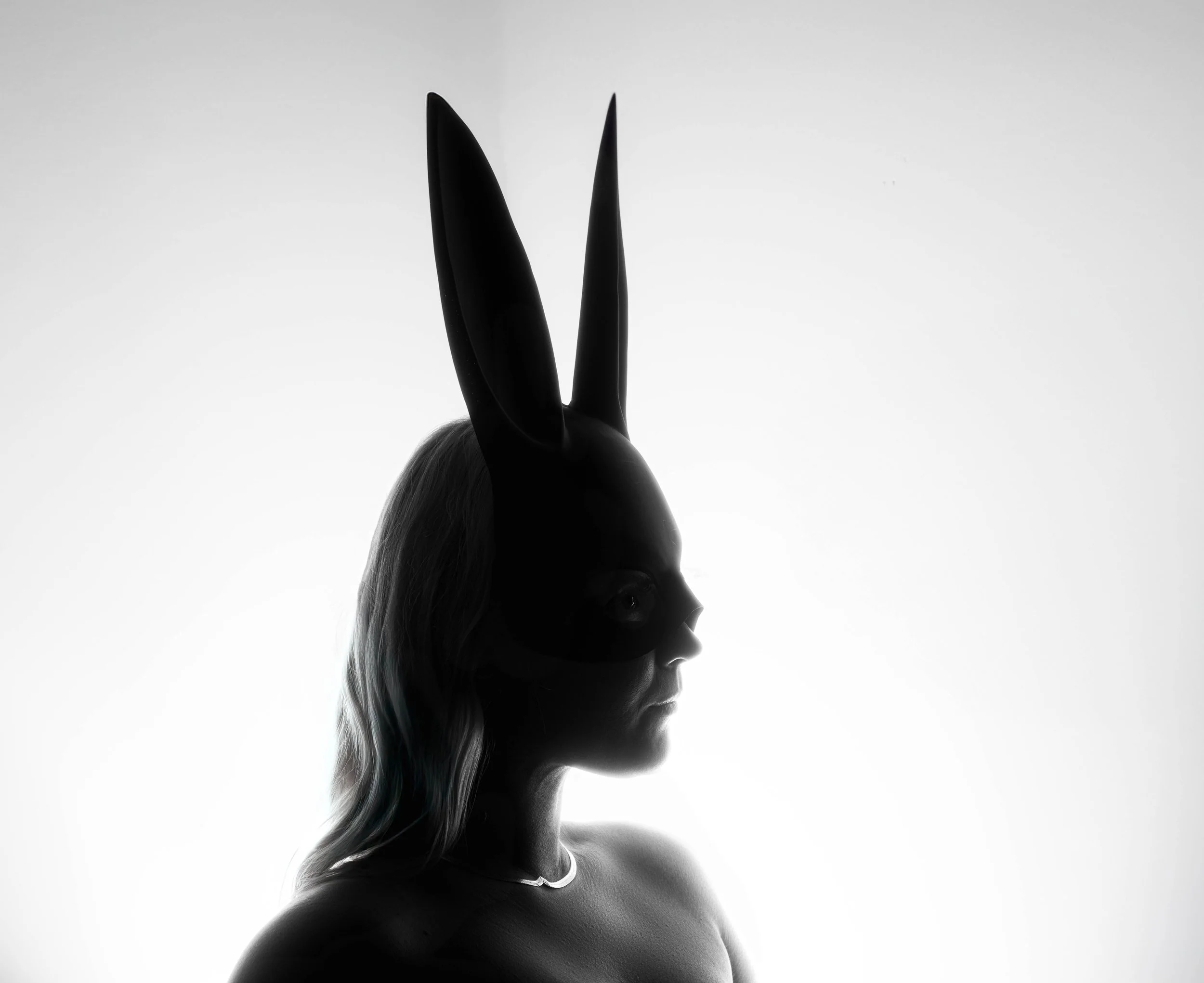 Black and White portrait of a woman in profile wearing a bunny mask