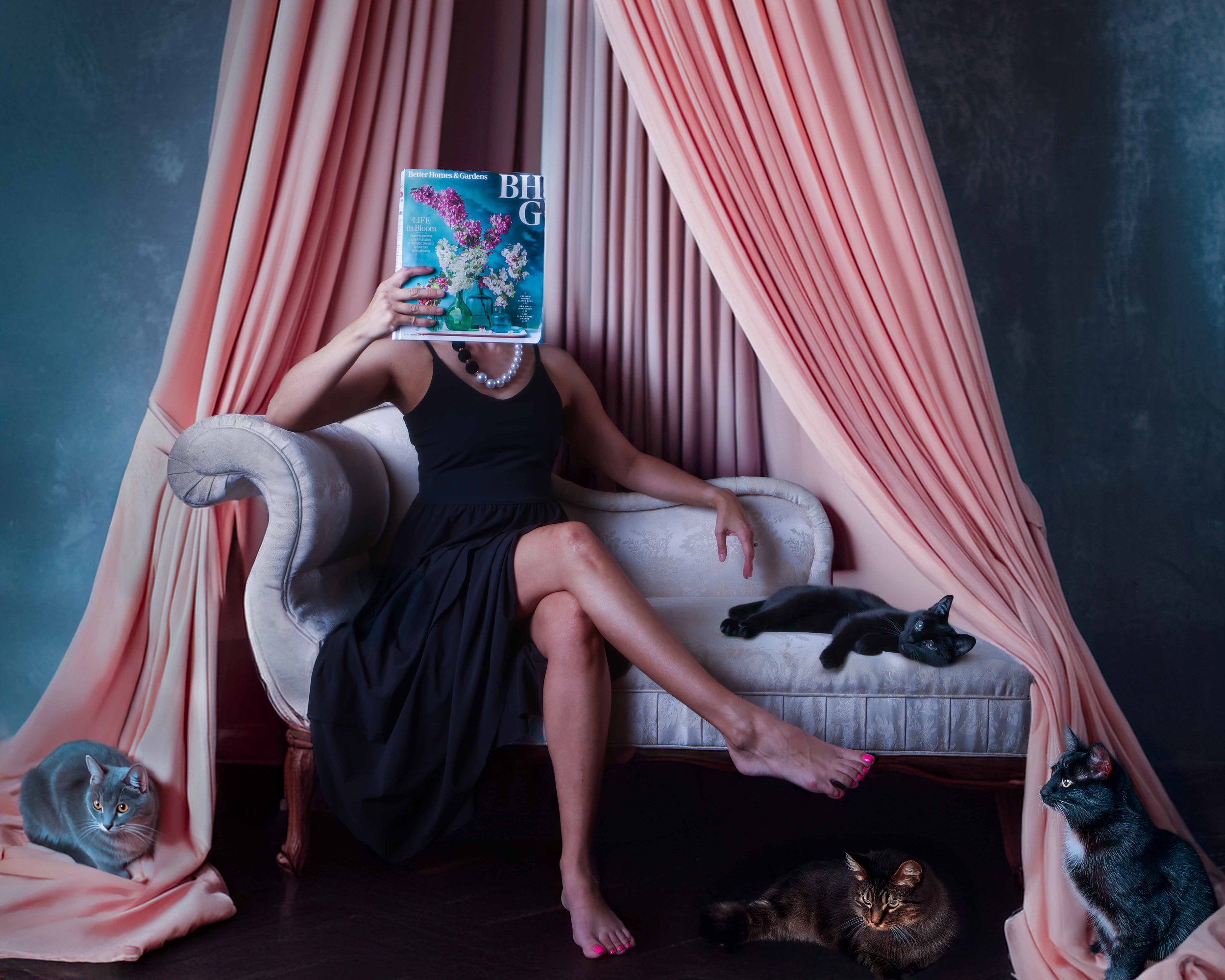 Self portrait of a woman sitting on a chaise lounge surrounded by cats 