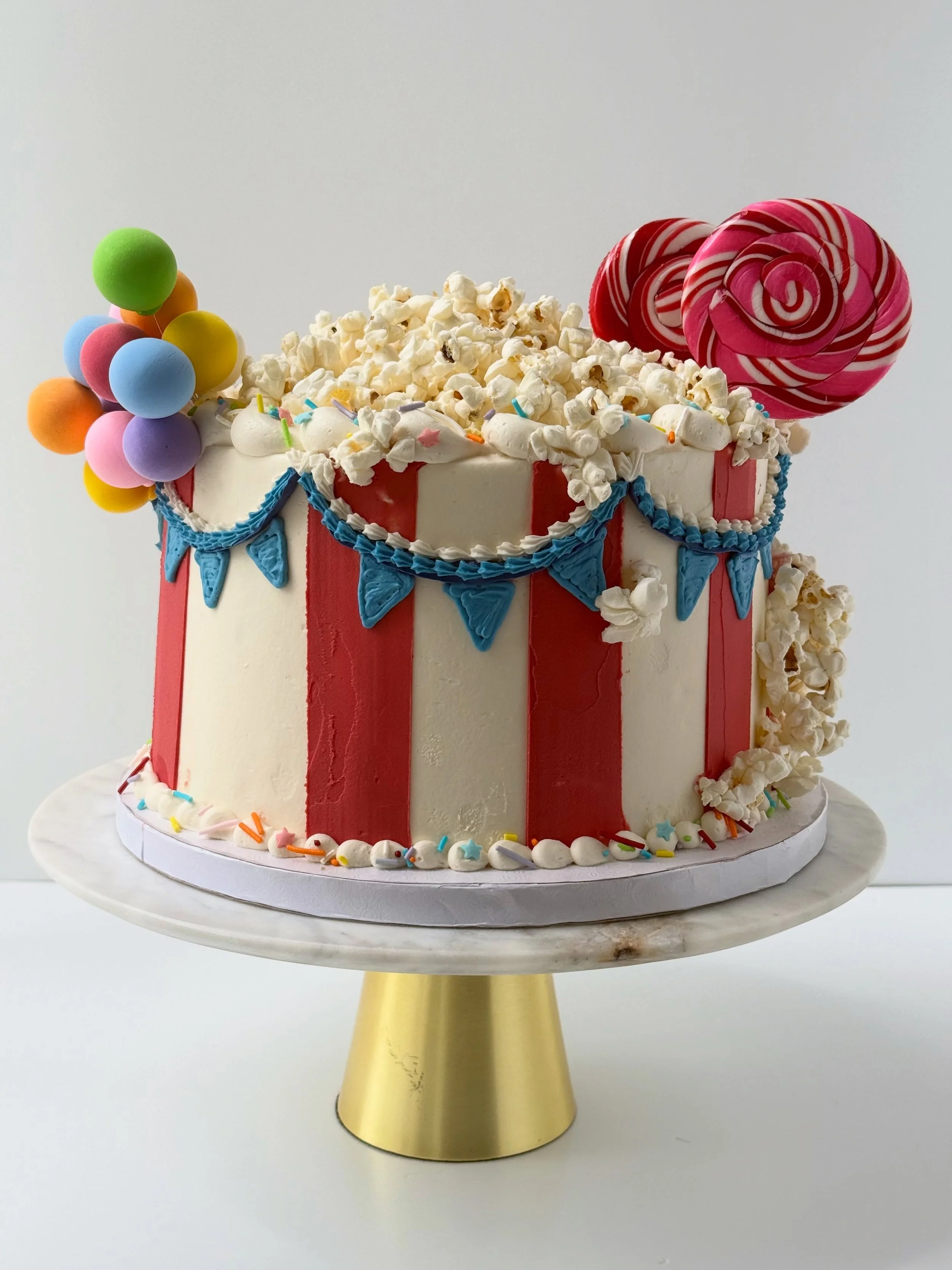 Circus Cake 🎪

✨shockingly the stripes were the hardest part of this cake 

✨cut straight strips of parchment paper and place them on a very cold cake. Add a thin layer of red buttercream and swipe it on

✨you&rsquo;ll like need a fridge break for t