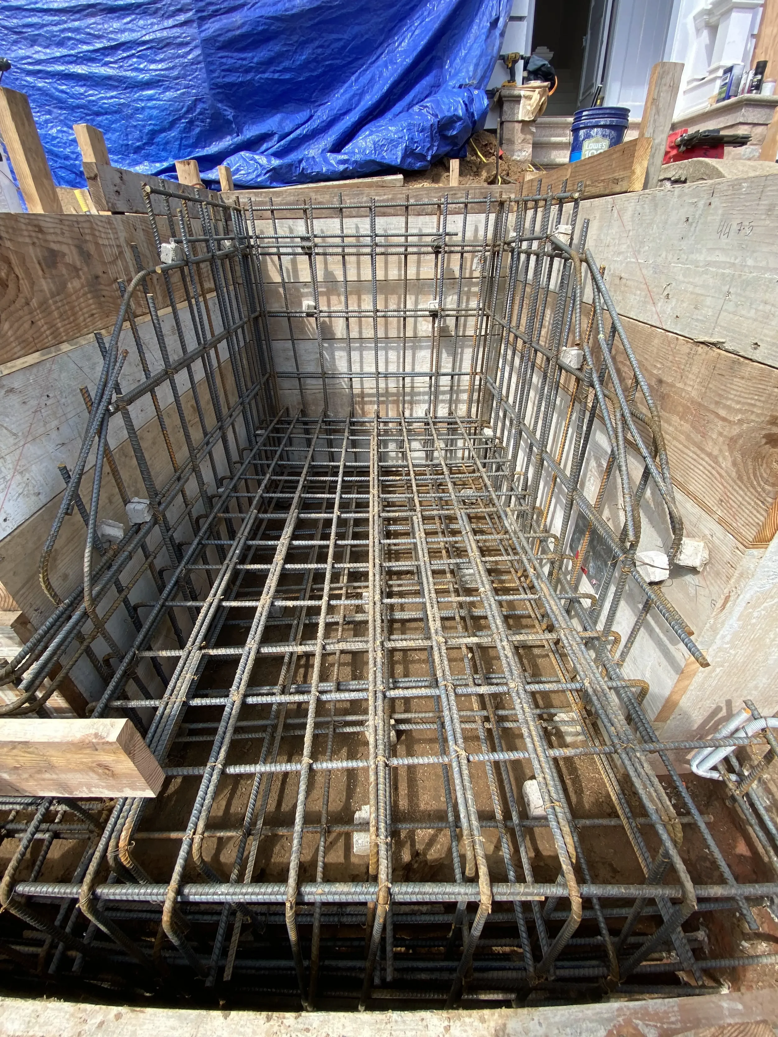 Concrete retaining wall with integrated drainage system and rebar cage designed by Massoudi Consulting Engineers