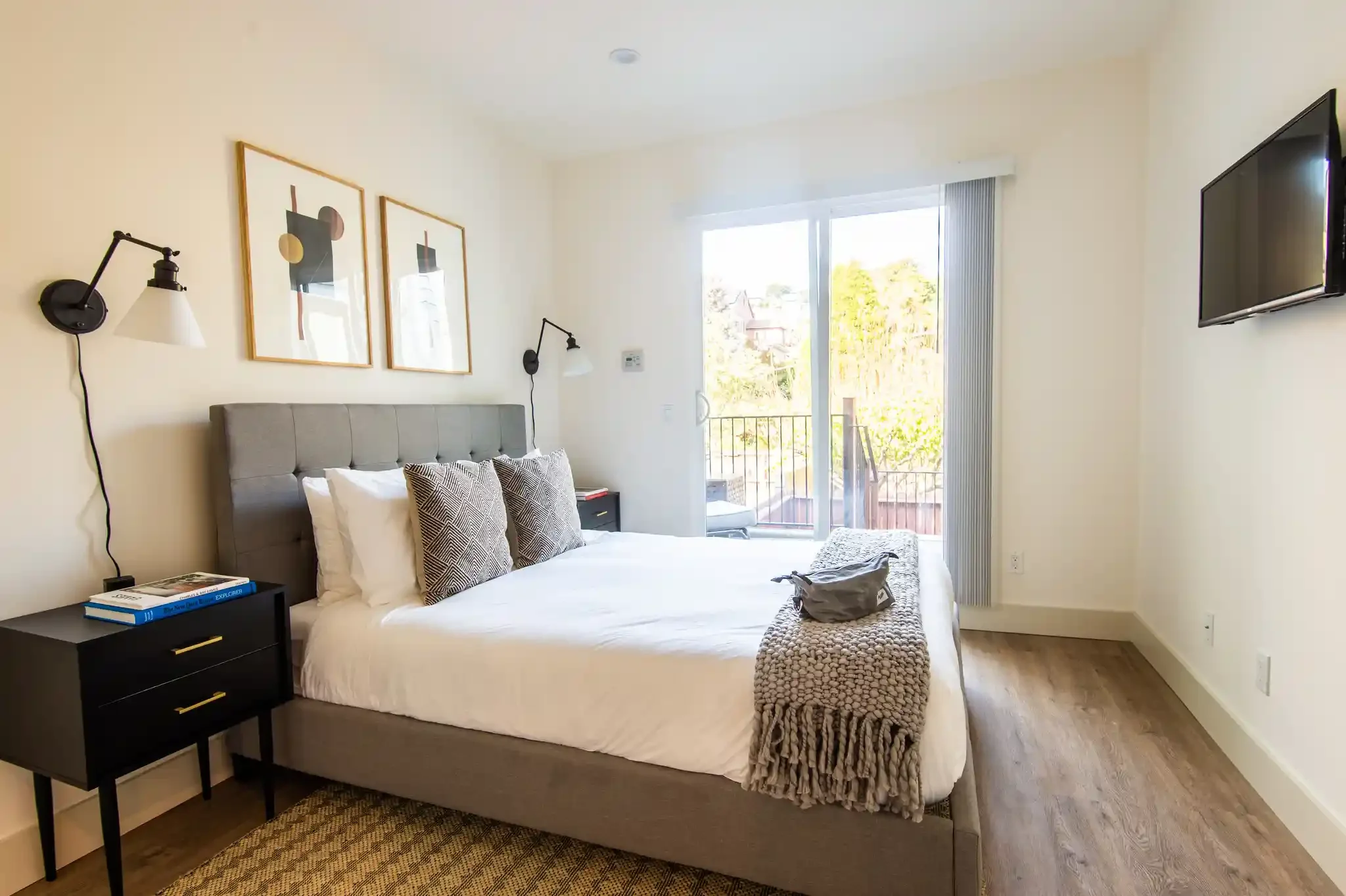 Bedroom with modern lighting and sliding doors leading to rear yard