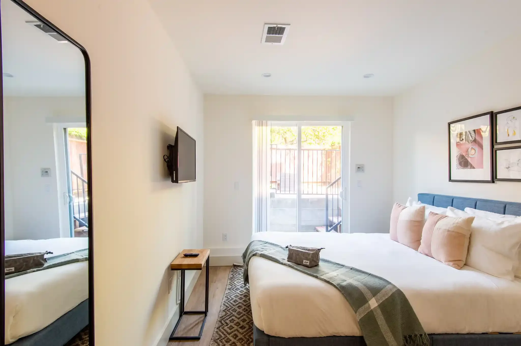 Bedroom with modern lighting and sliding doors leading to rear yard