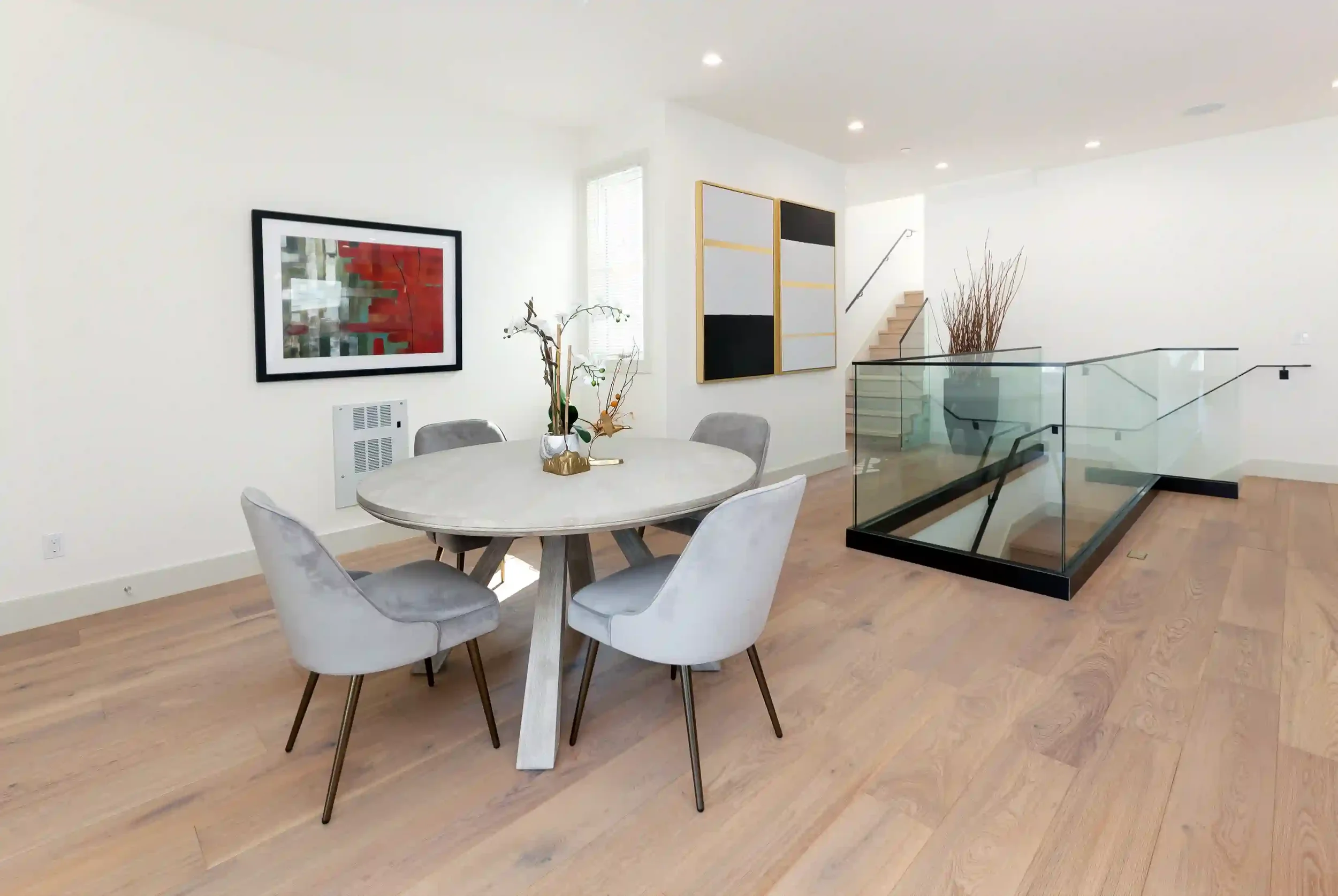 Dining area and stair access showing structural glass railing and modern space planning