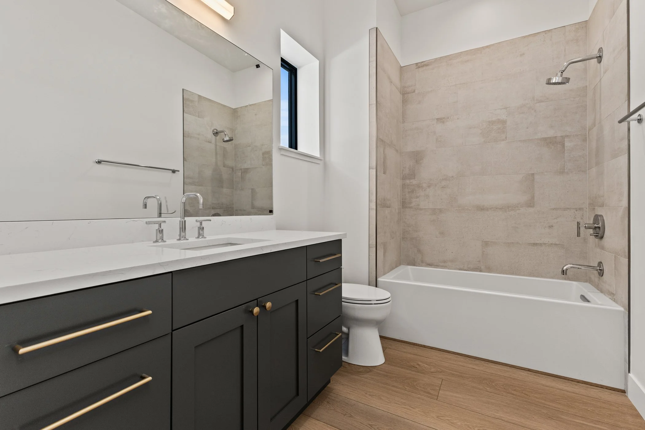 Modern bathroom with vanity, sink, mirror, bathtub, and shower.