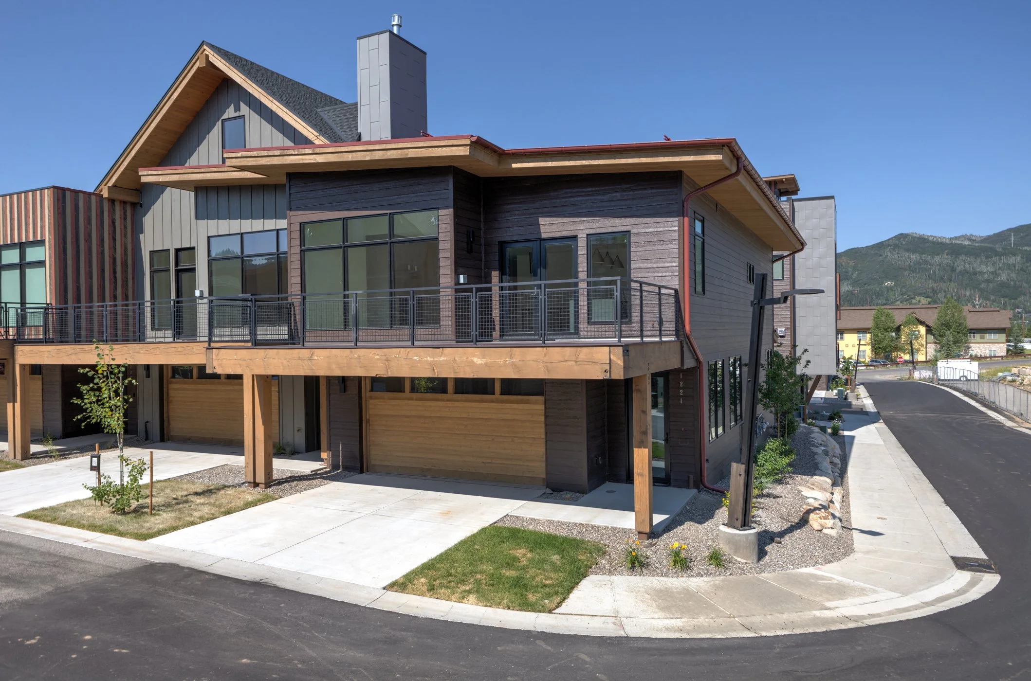 Modern townhouse with garage and balcony in suburban neighborhood.
