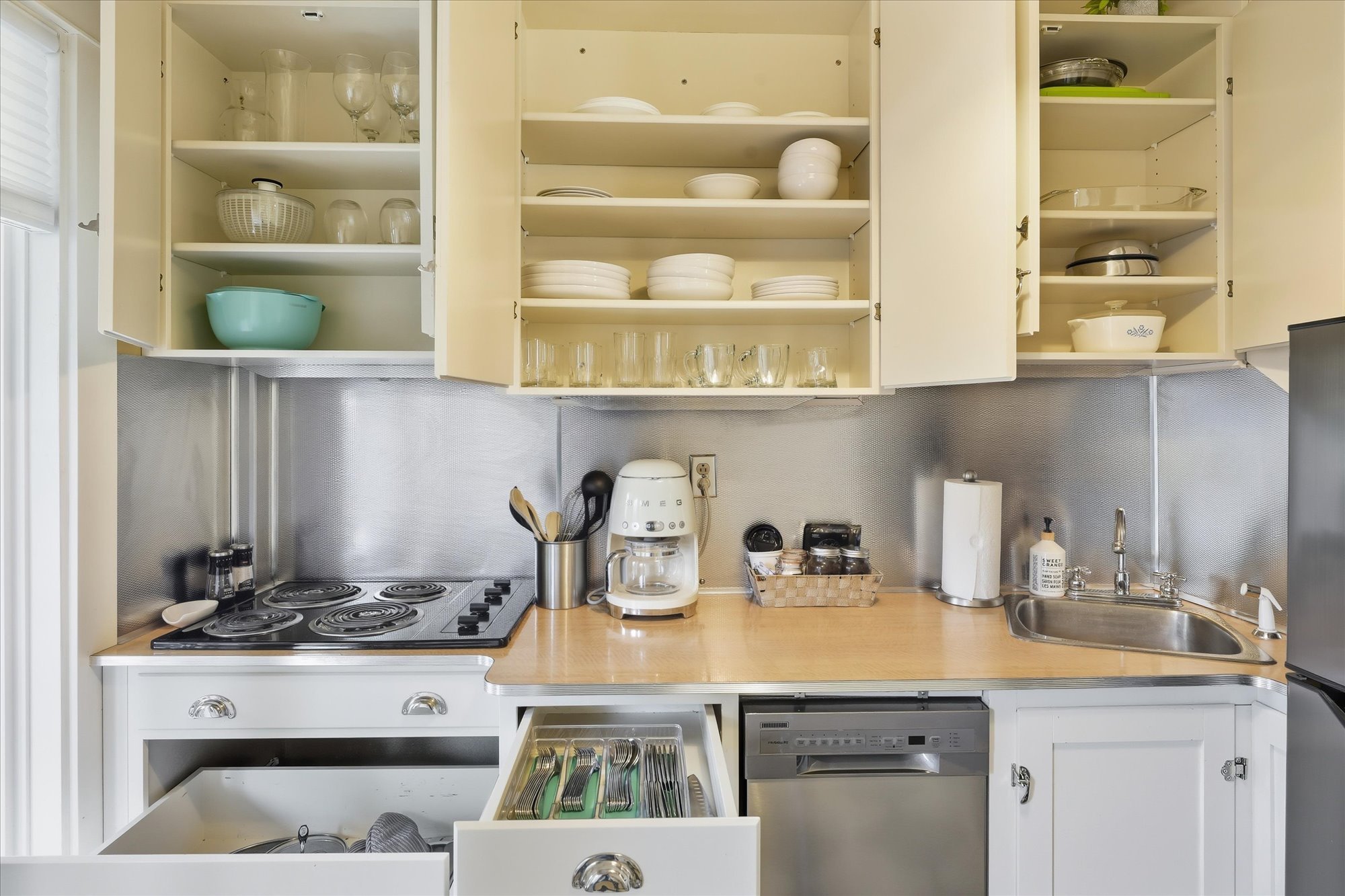 wine glasses, cups, dishes, bowls, cutlery, pots and pans are also conveniently on hand.