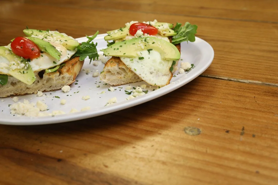 Fried eggs, spinach, avocado, feta cheese, on toasted baguette.