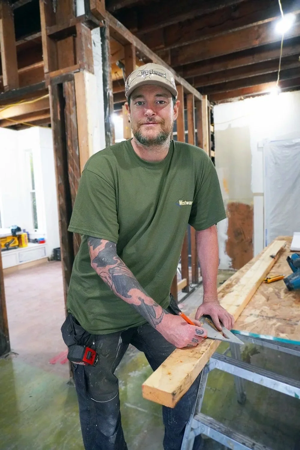 A photo of a carpenter measuring a 2x4