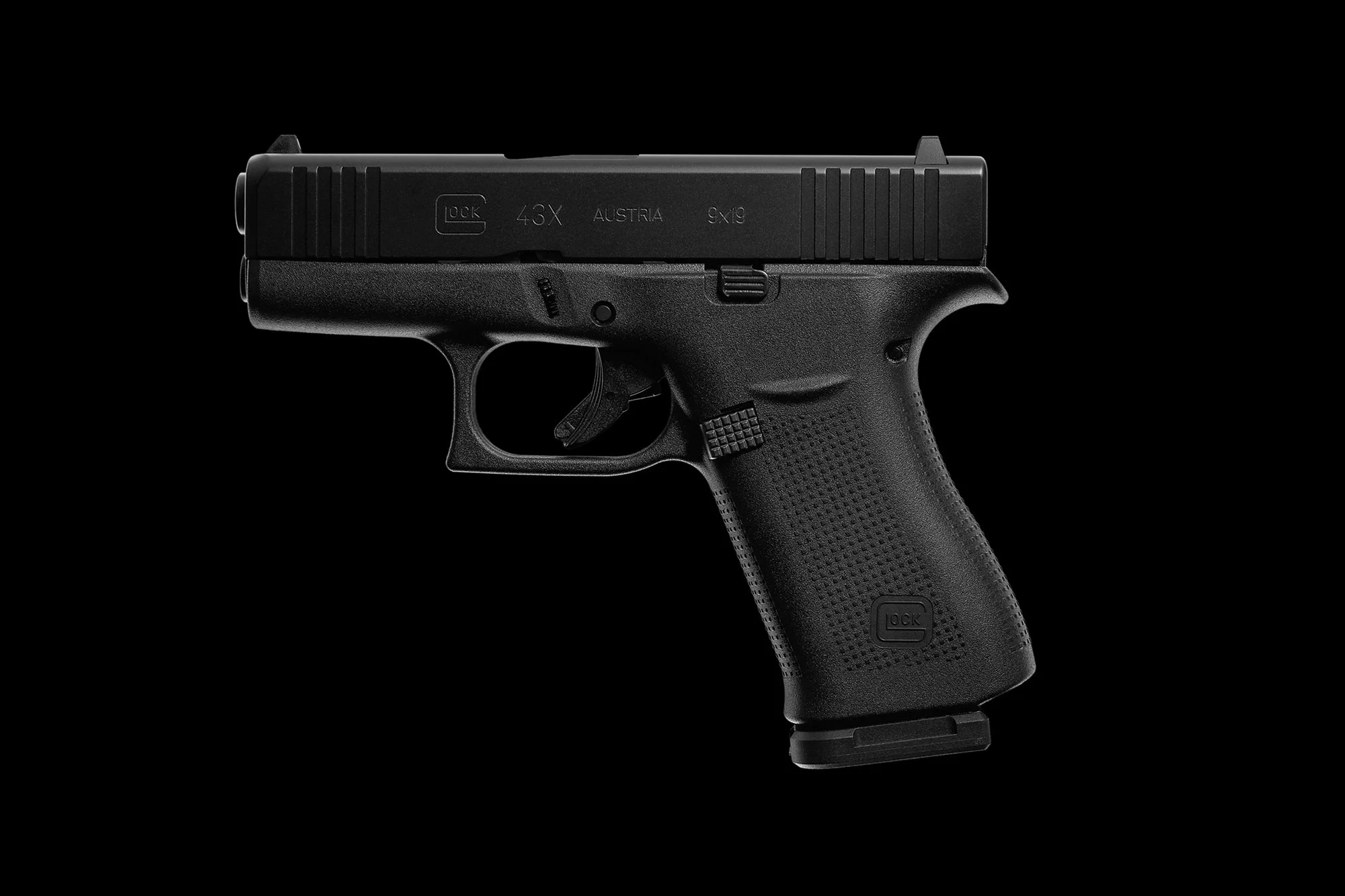 A black handgun with a textured grip and a slide marked Glock 43X Austria 9x19, placed on a black background.