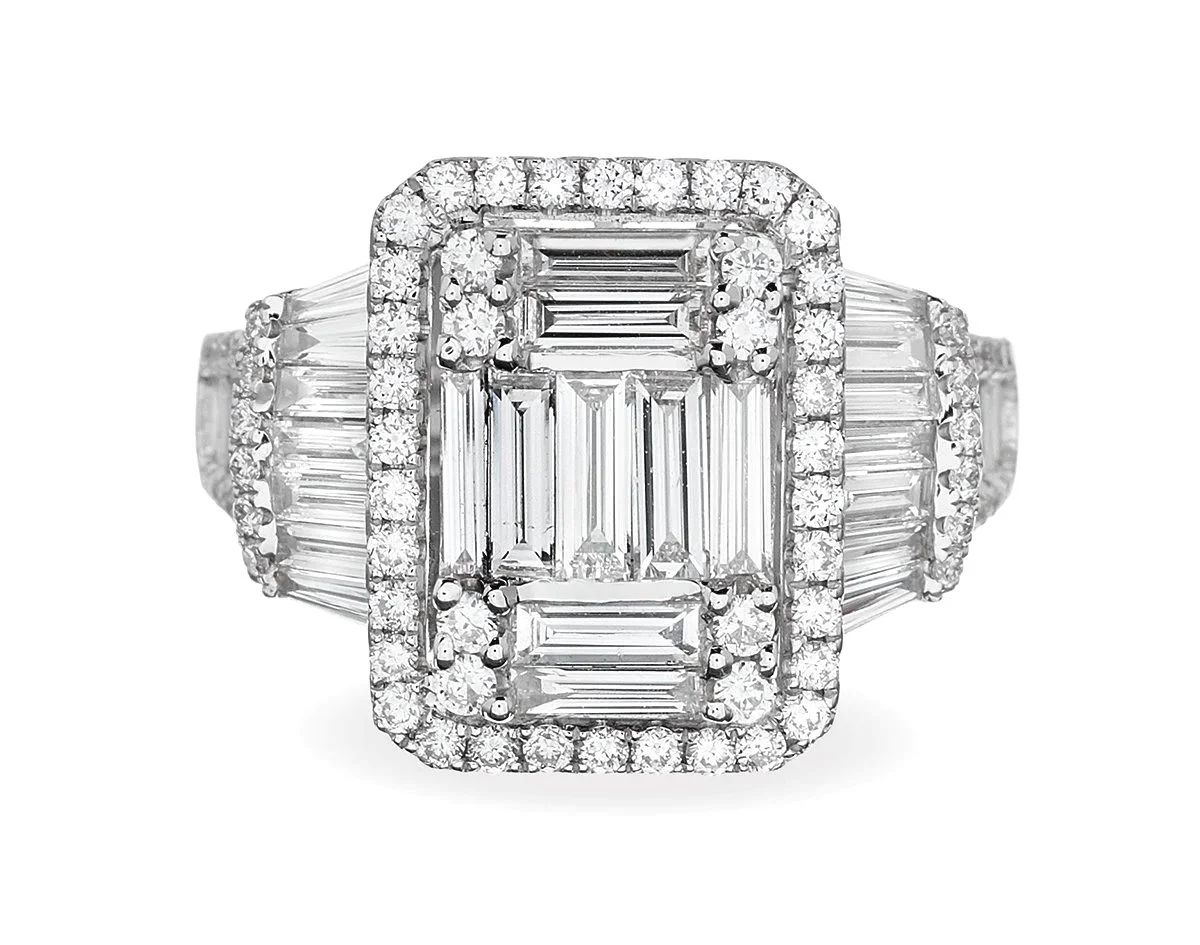 Luxury diamond ring with a large emerald cut center stone composed of multiple baguette-cut diamonds, surrounded by a halo of smaller round diamonds on white background.