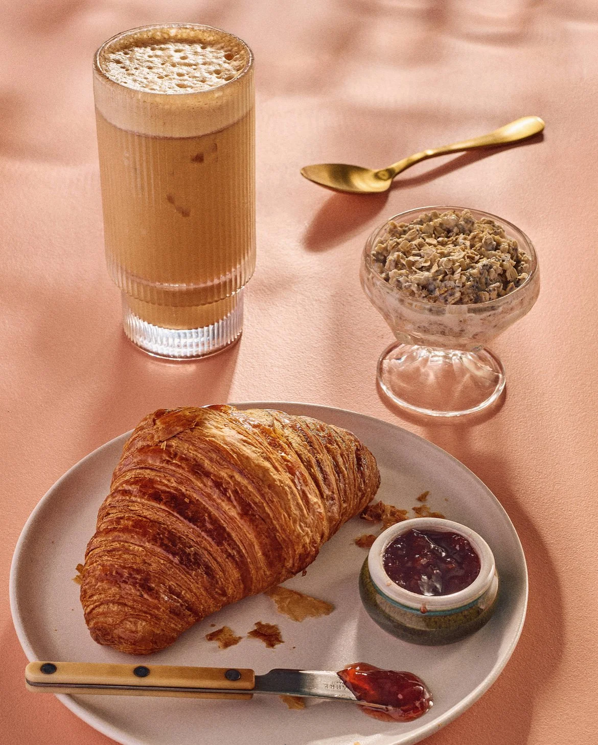 Balthazar butter croissant with strawberry preserves. accompanied by- L'SETTE Chia & Coconut Ov'night oats, and a Shaken Honey Vanilla.