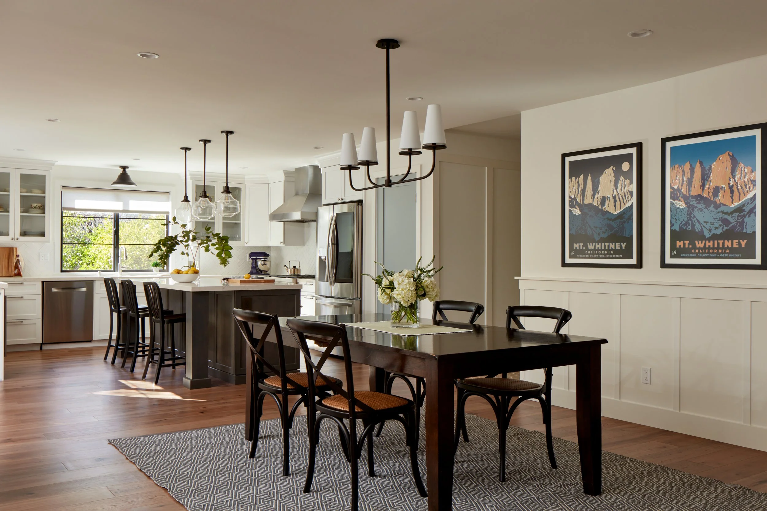 Open-concept kitchen and dining area remodel in Pacifica with hardwood floors, custom lighting, and modern finishes.
