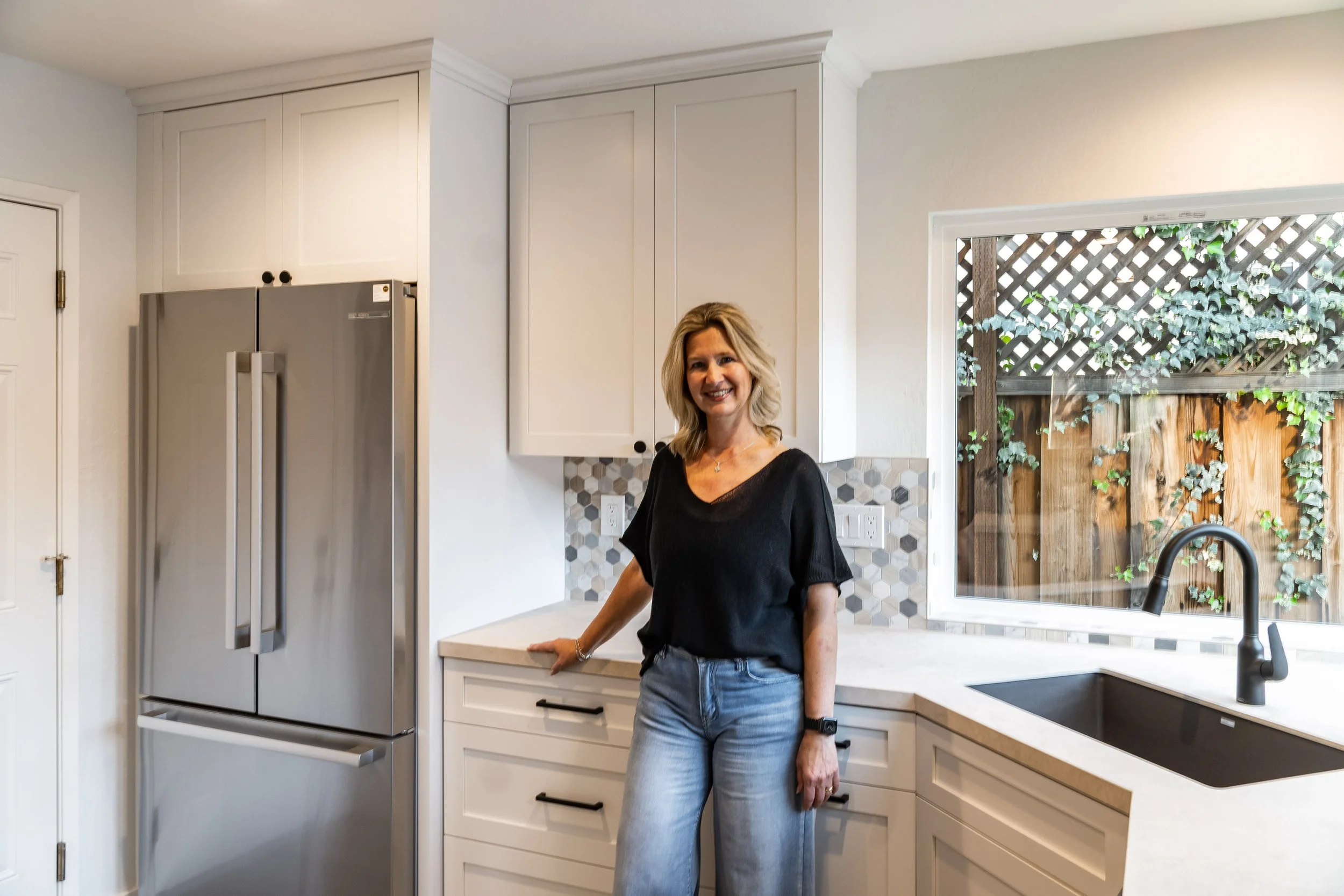 Project designer Petra standing in the completed San Jose kitchen, showcasing custom cabinets, modern finishes, and natural light.