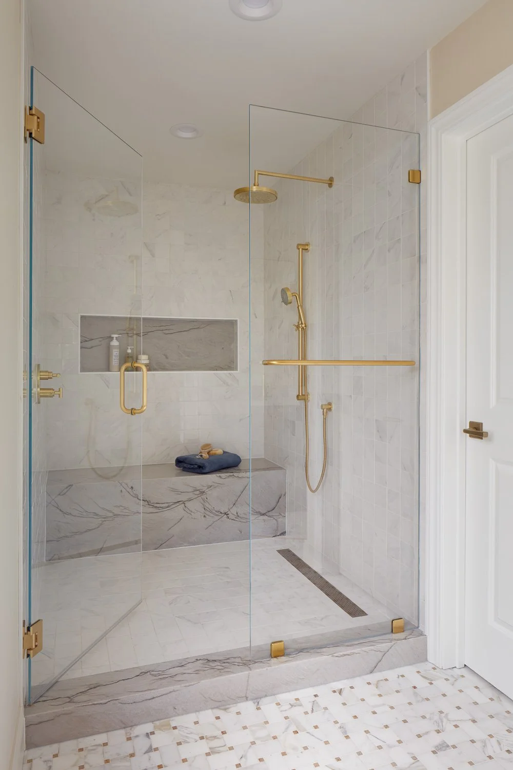 Spa-like shower with slab walls and brass fixtures – custom home remodel