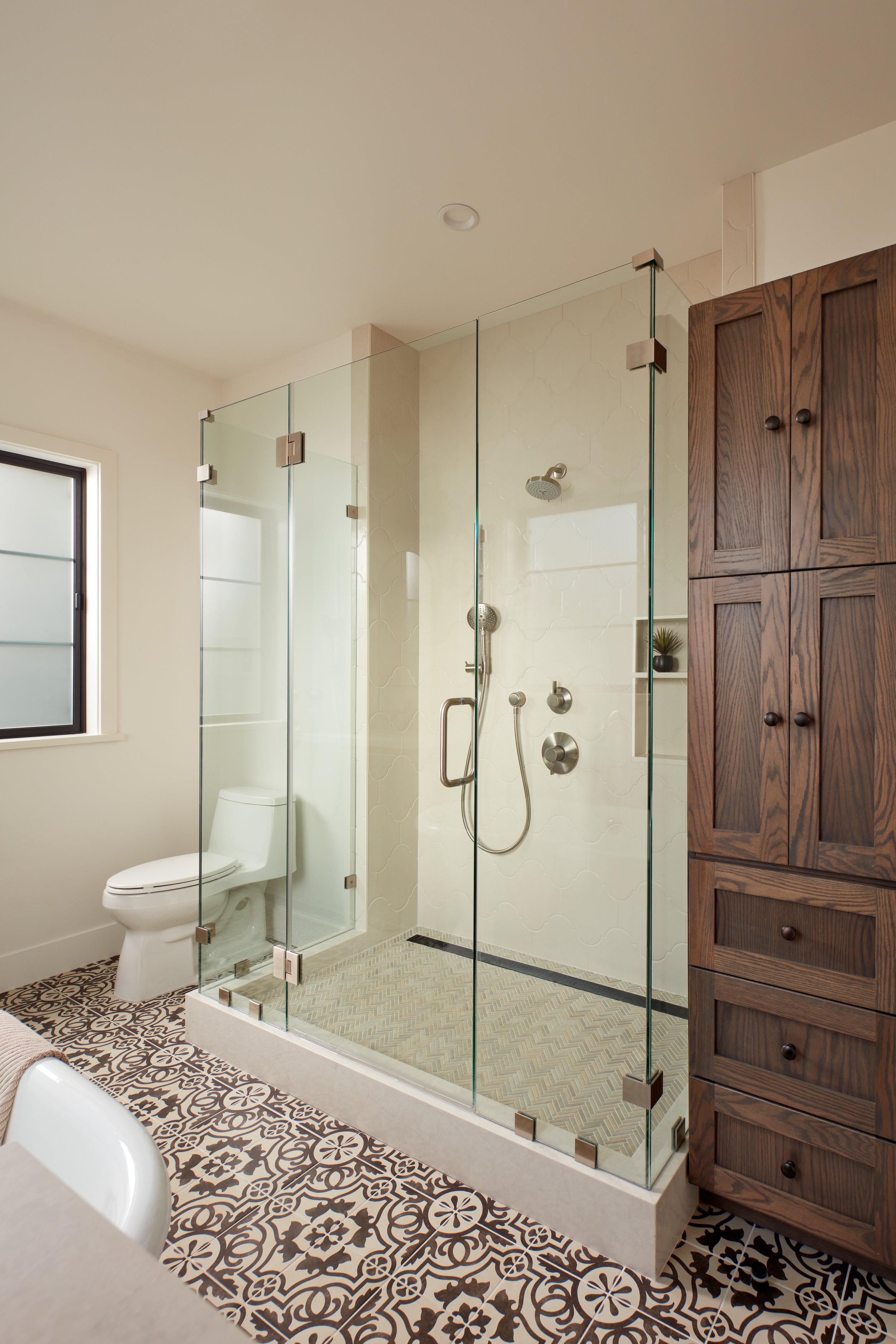 Custom walk-in shower with frameless glass, designer tile, and modern fixtures in Pacifica home remodel
