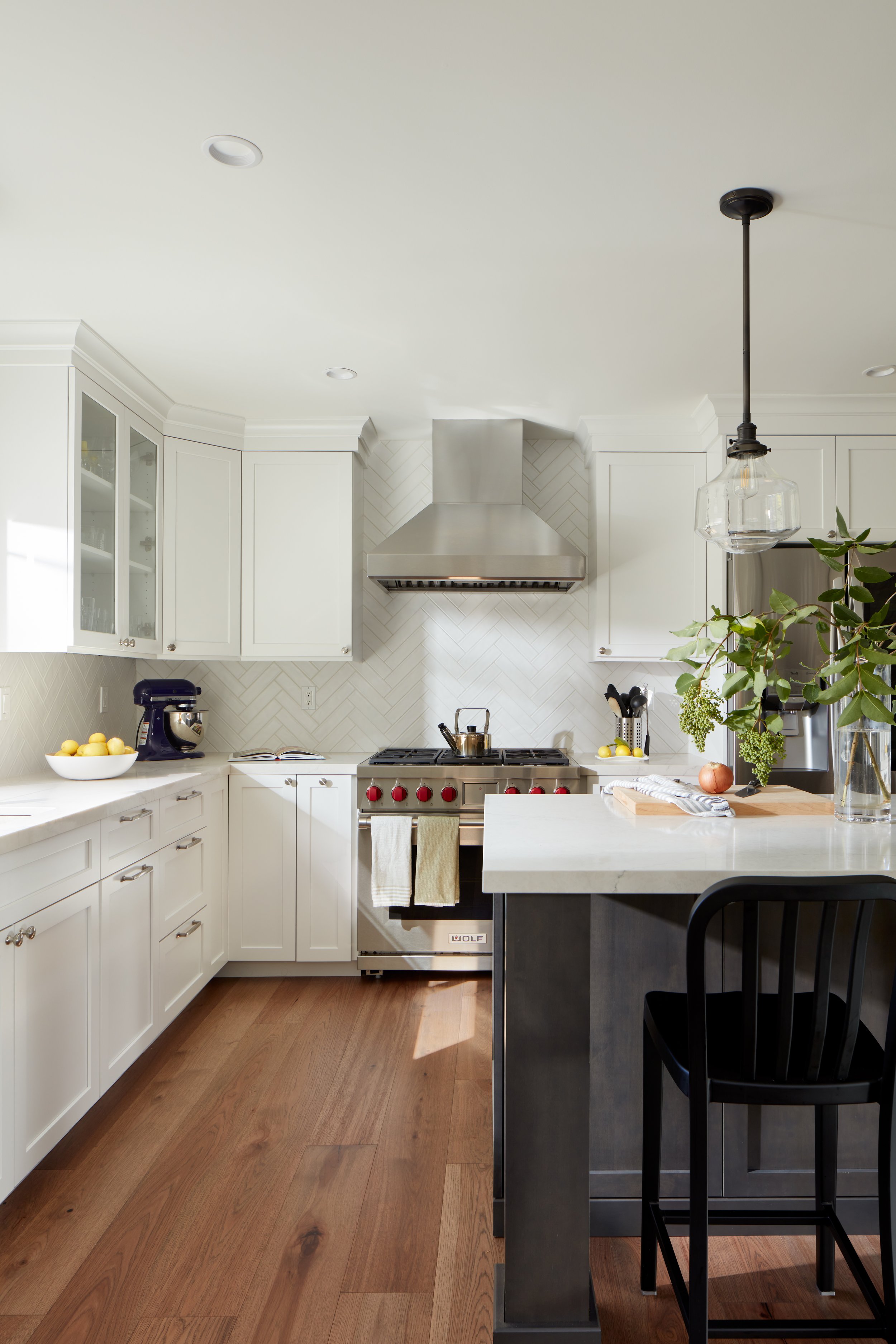High-end Pacifica kitchen remodel with stainless steel range, custom hood, white cabinets, and spacious island.