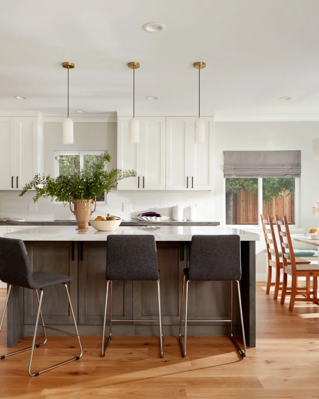 There is something incredibly timeless about a crisp, white kitchen that balances classic charm with modern functionality. From the beautifully detailed dark island contrast and matching statement range hood to the intricate mosaic tile backsplash, t