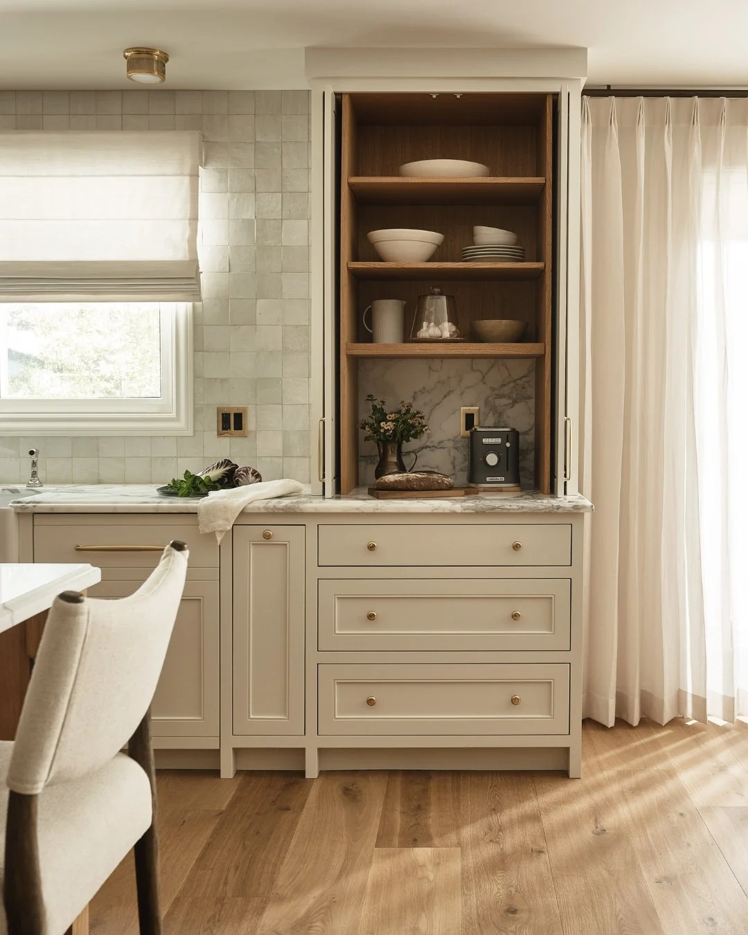Now you see it, now you don't. ☕✨ This custom appliance garage and coffee station is the ultimate blend of function and seamless design. Pocket doors effortlessly tuck away to reveal warm wood shelving, marble backing, and everyday essentials, then s