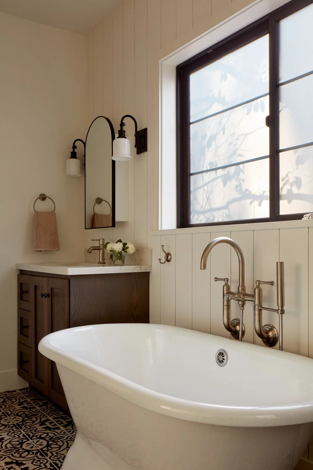 Freestanding soaking tub with custom wood vanities, patterned tile flooring, and soft natural light in Pacifica master bathroom remodel