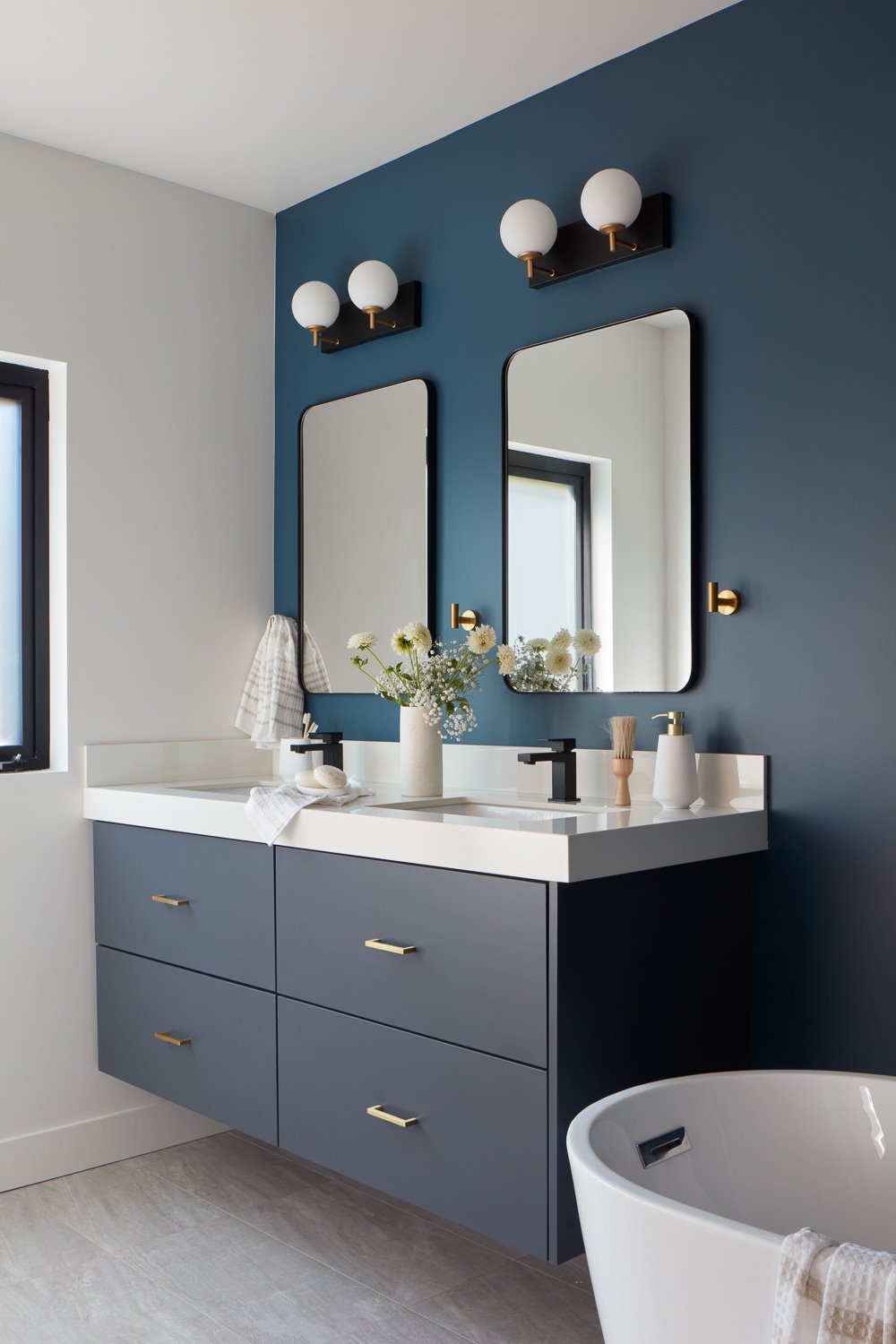A modern double vanity with custom finishes adds balance and function to this new construction primary bathroom.