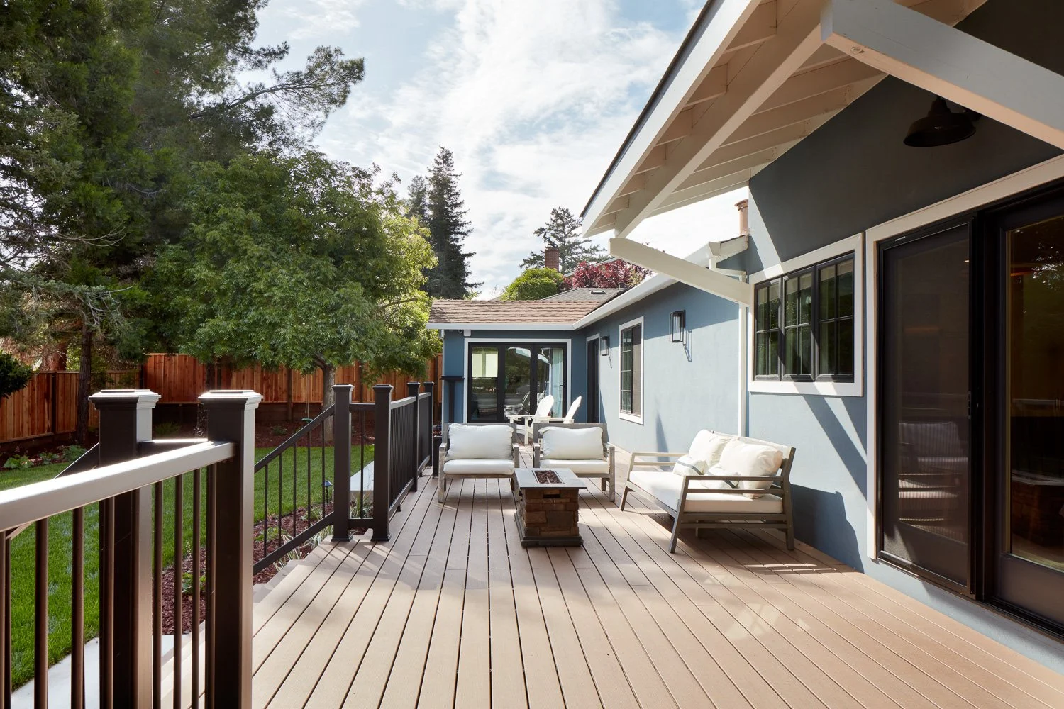Covered outdoor lounge with composite decking and clean detailing – custom home remodel.