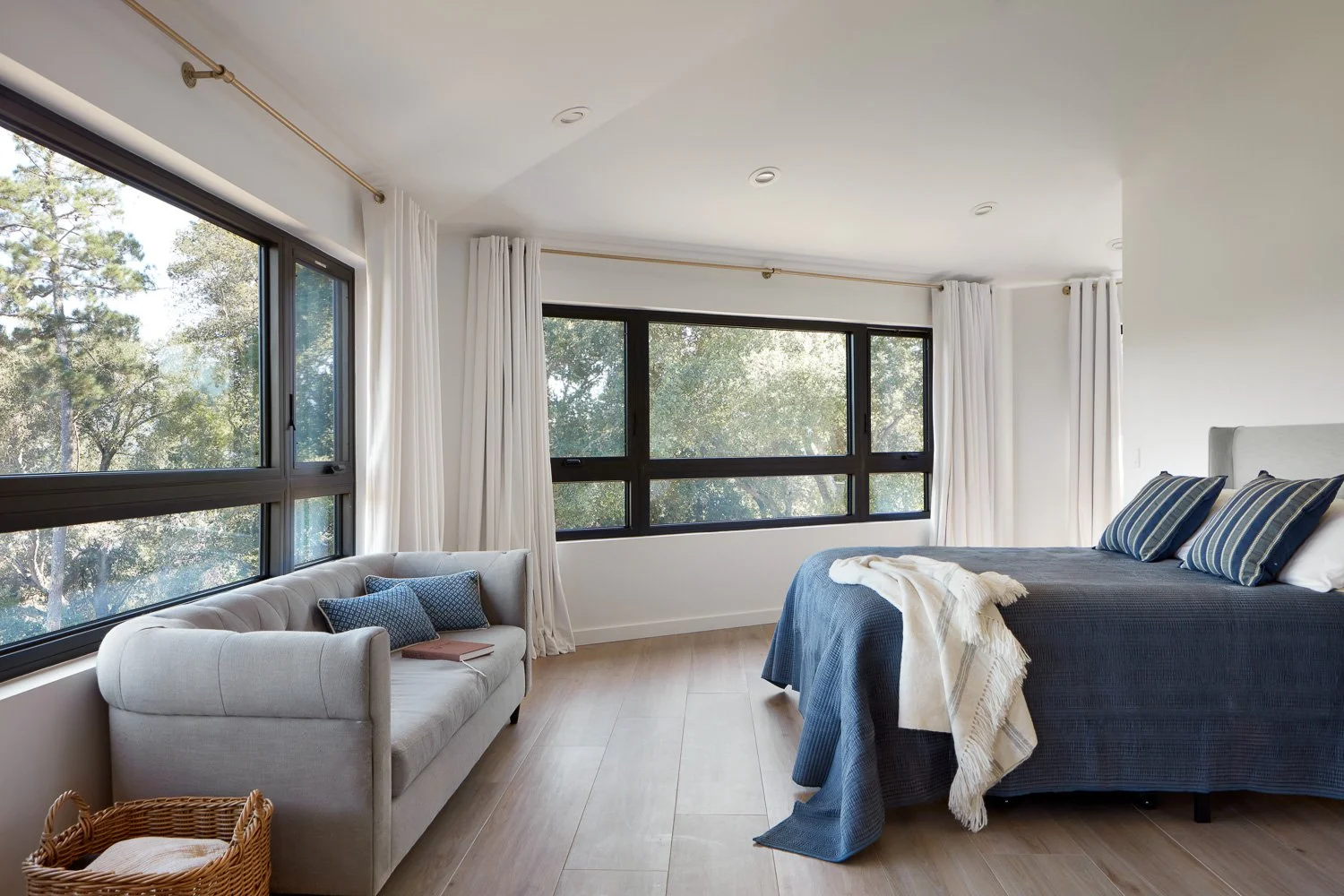 Primary bedroom designed for calm and comfort, with expansive windows, soft textures, and peaceful hillside views.