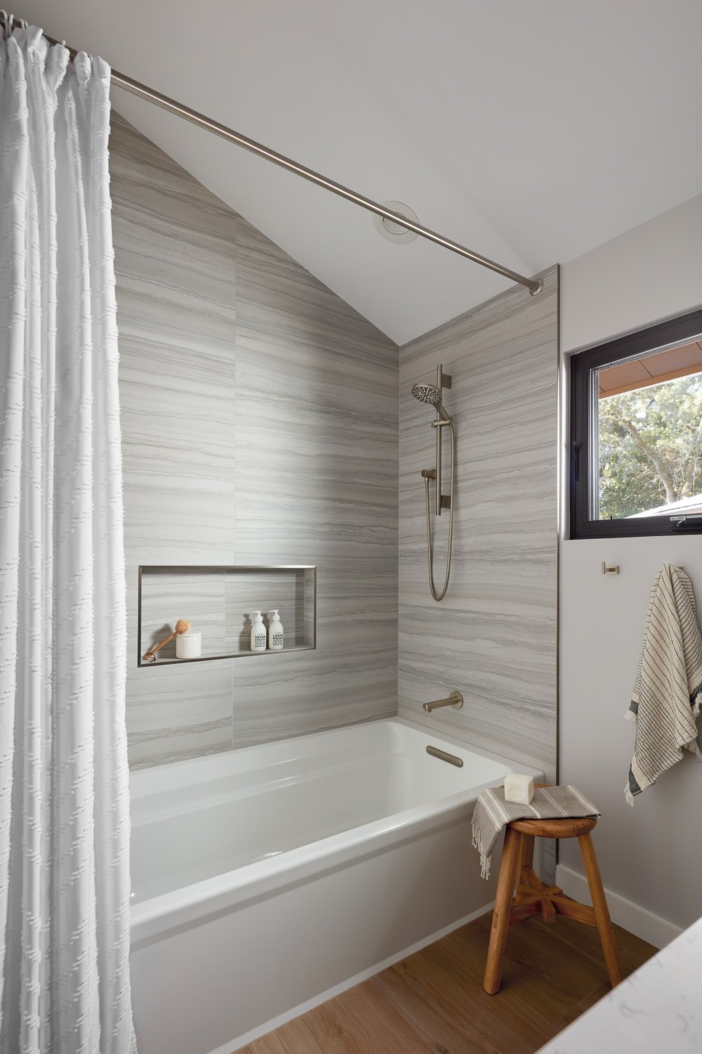 Large-format tile and a built-in tub create a serene, spa-inspired bath designed for everyday luxury.