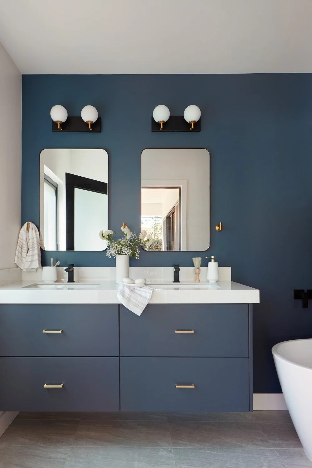 A modern primary bathroom with dual vanity and clean finishes, designed as part of a luxury new construction residence.