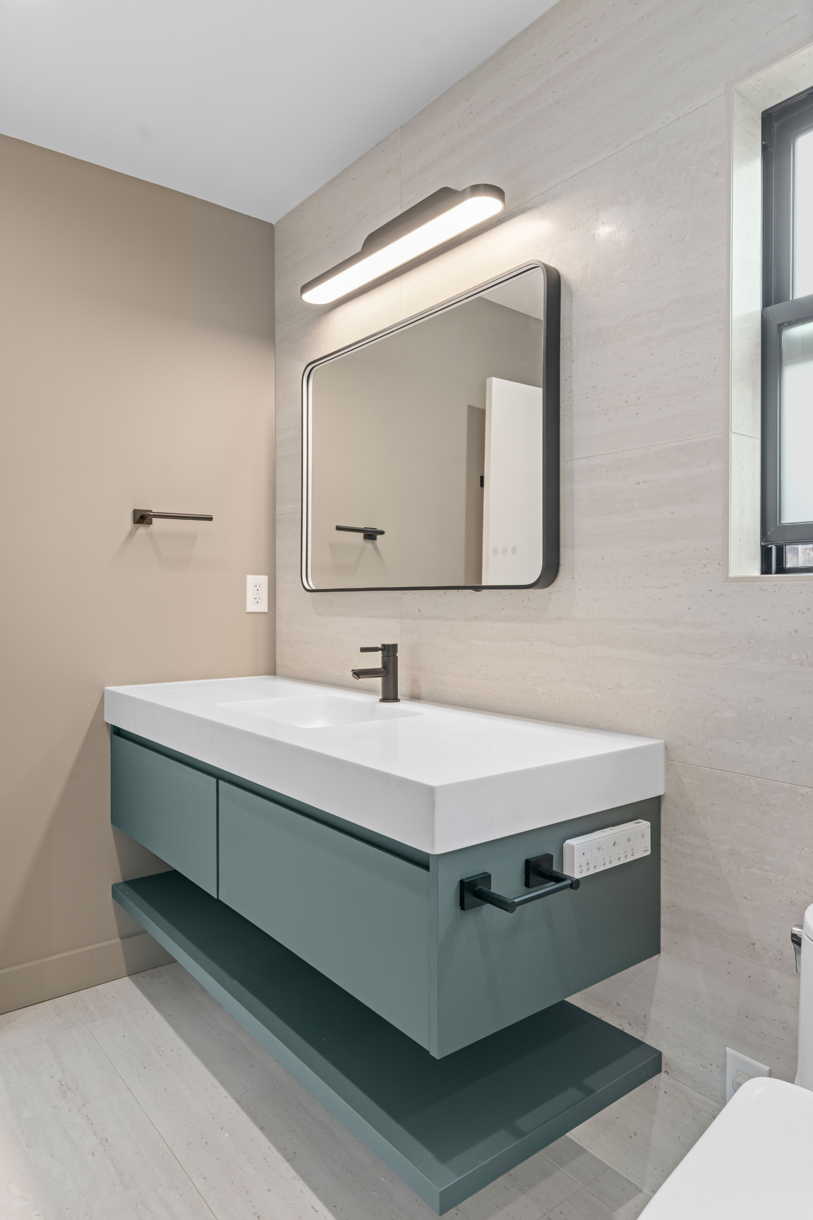 Contemporary bathroom featuring a floating vanity, integrated sink, LED mirror, and premium finishes in this custom ADU.