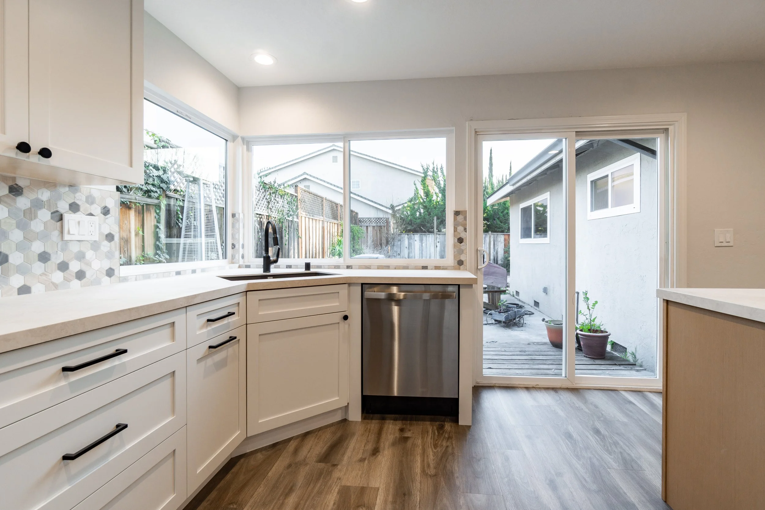 Stainless steel range with modern control panel and hex tile backsplash in a remodeled San Jose kitchen.