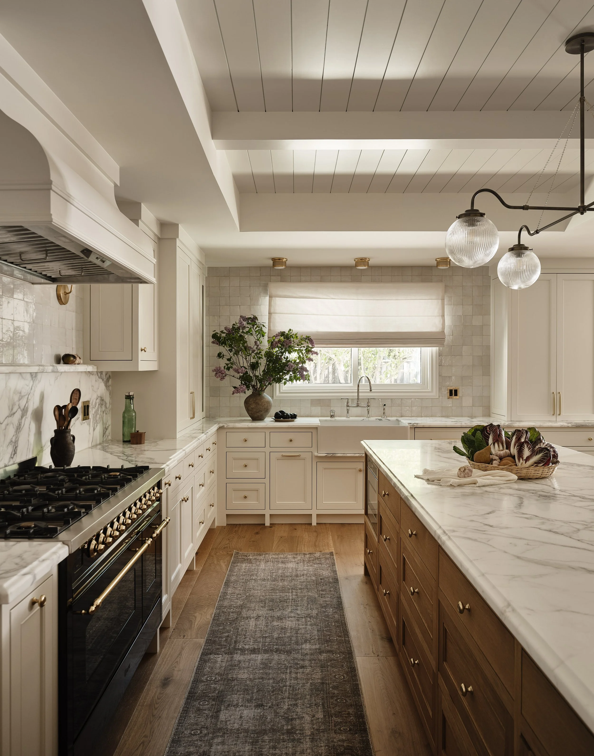 Statement kitchen island with waterfall countertop in this high-end Addition & Full Home Remodel.