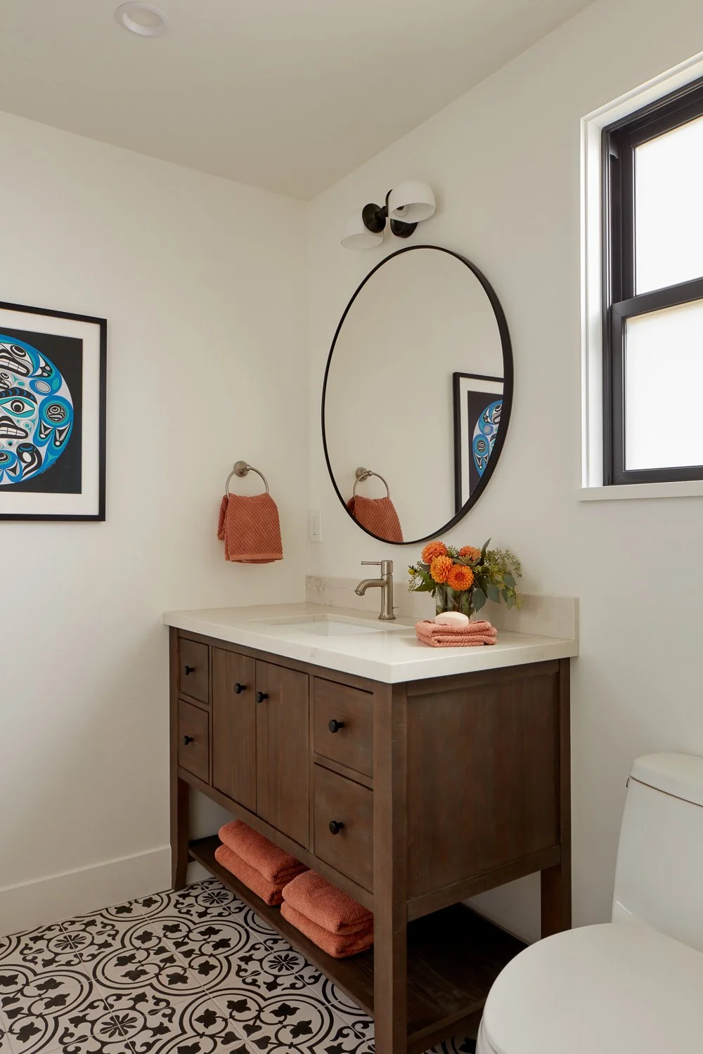 Custom wood bathroom vanity with quartz countertop, wall-mounted mirror, and designer tile flooring in Pacifica remodel.