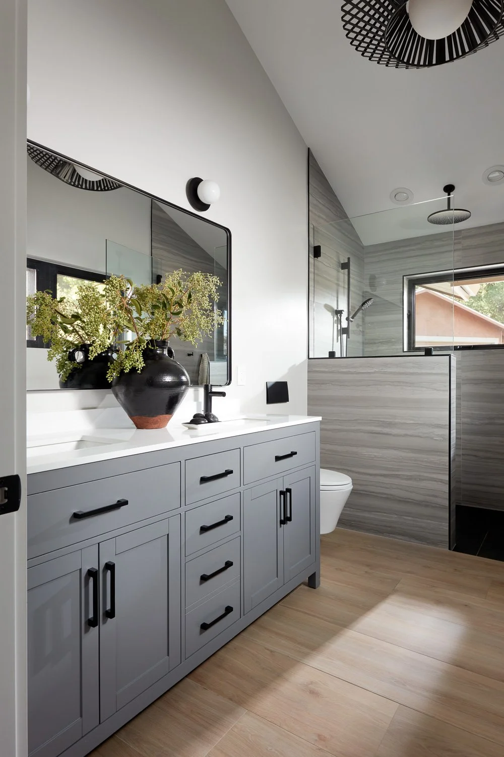 Sleek gray vanity, modern fixtures, and clean lines create a calm, spa-like bathroom retreat.