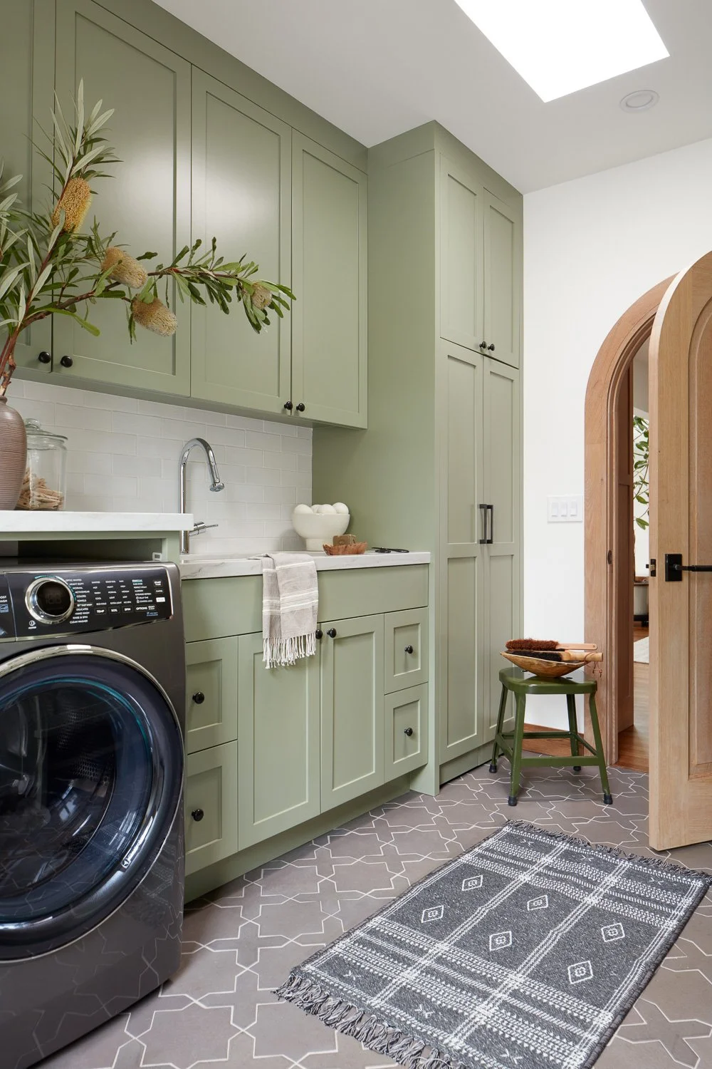 Spanish-style powder bath featuring arched window, custom vanity, and designer wallpaper in a San Mateo home renovation.