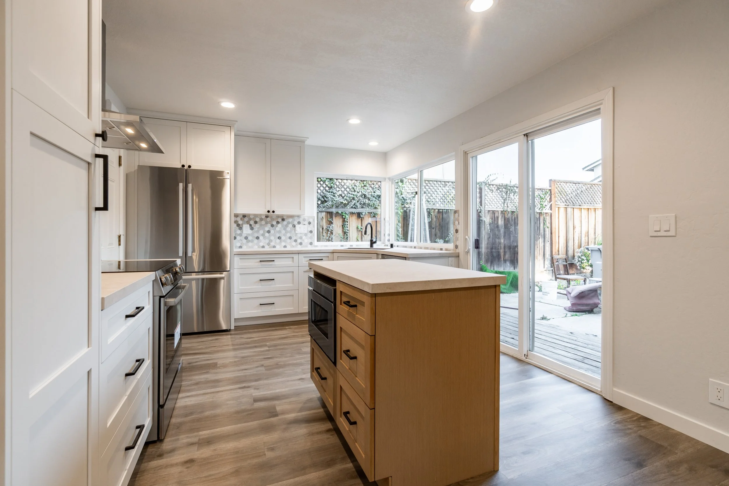 Contemporary kitchen island with warm wood base, built-in storage, and quartz countertop.