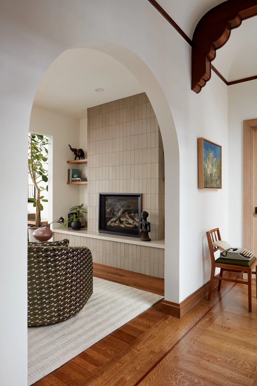 A cozy fireplace framed by custom arches and built-ins, blending classic character with modern living.