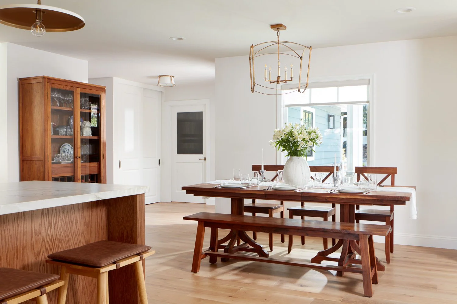 Open dining space with warm wood tones and natural light – custom home remodel.