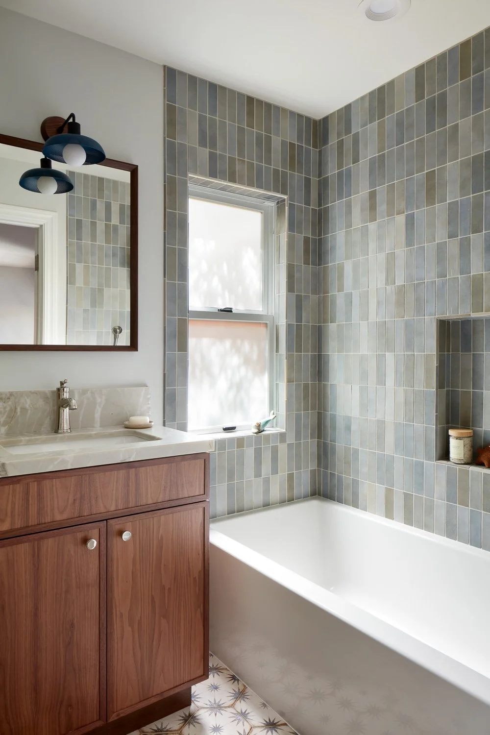 Contemporary bath with vertical tile and warm wood vanity – custom home remodel.